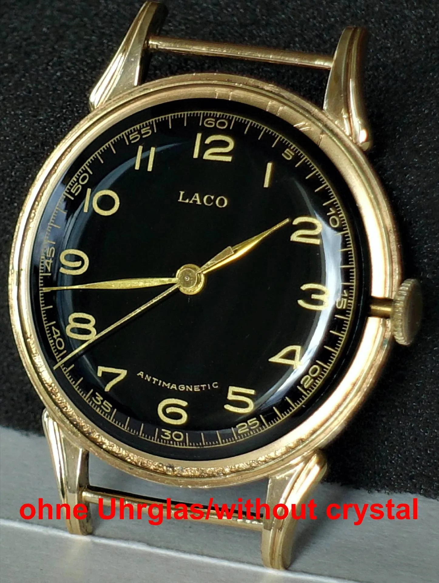 Schwarzes Zifferblatt, gelbgoldenes Gehäuse, Vintage-Uhr Eine Armbanduhr mit schwarzem Zifferblatt und gelbgoldenem Gehäuse, ohne Uhrglas.