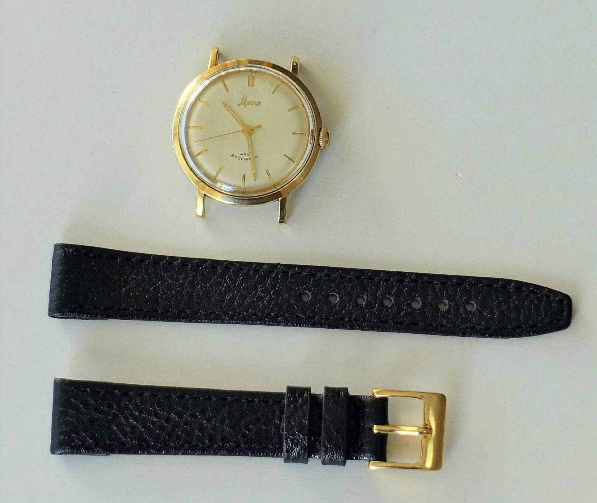 Goldfarbene Armbanduhr mit Lederband Zerlegte Armbanduhr mit goldfarbenem Gehäuse und schwarzem Lederarmband.