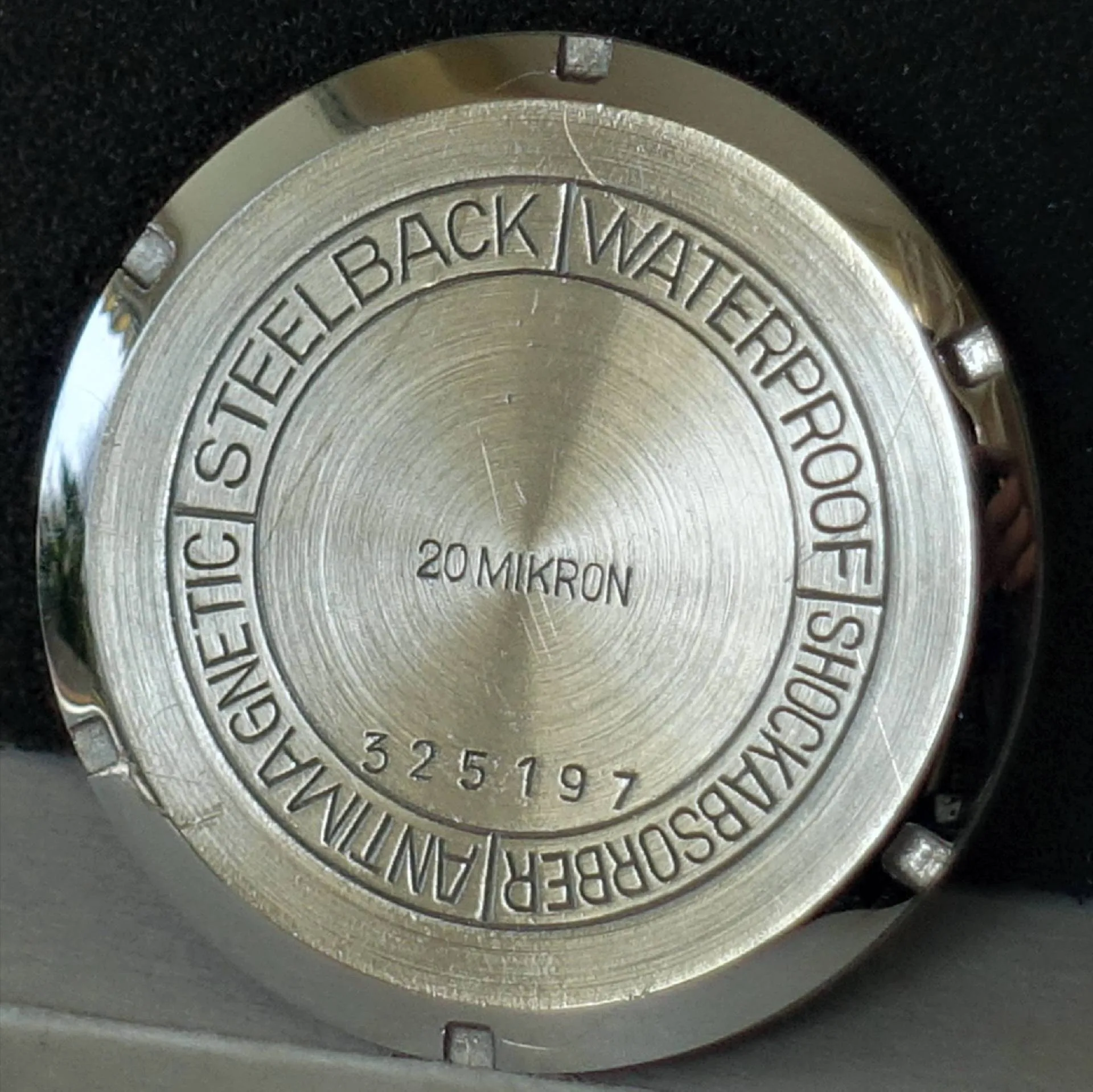 Uhrenboden silberfarben Runder silberfarbener Uhrenboden mit Gravur und Seriennummer.
