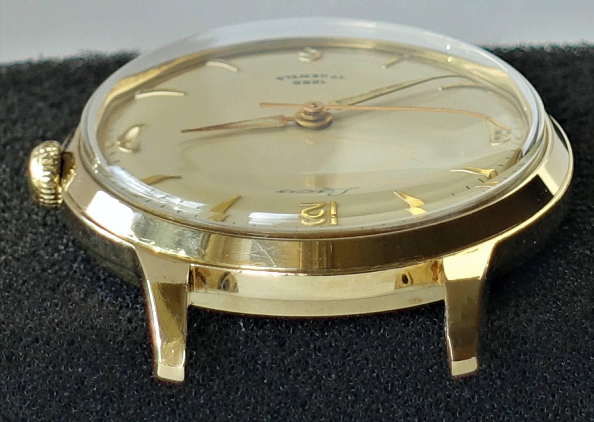 Goldfarbene Armbanduhr mit hellem Zifferblatt und goldenen Indizes.