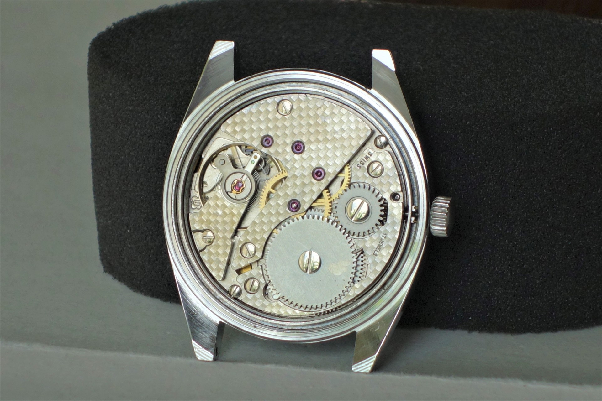 Silberfarbenes mechanisches Uhrwerk in einem offenen Uhrengehäuse.