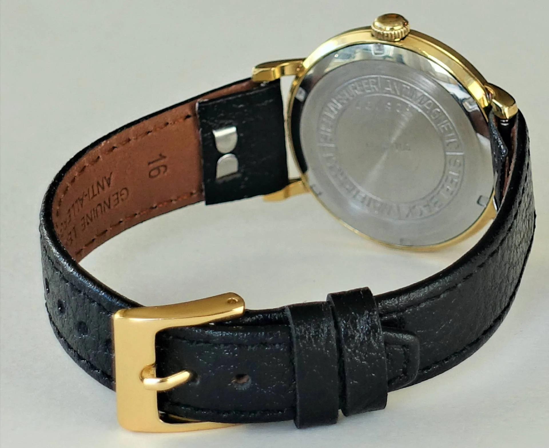 Armbanduhr schwarz goldfarben Schwarze Armbanduhr mit goldfarbenem Gehäuse und schwarzem Lederarmband.