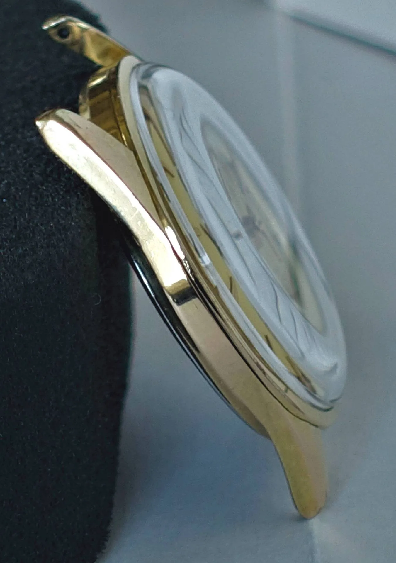 Gehäuse goldfarben Goldfarbenes Uhrengehäuse mit montiertem Uhrglas, seitliche Ansicht.