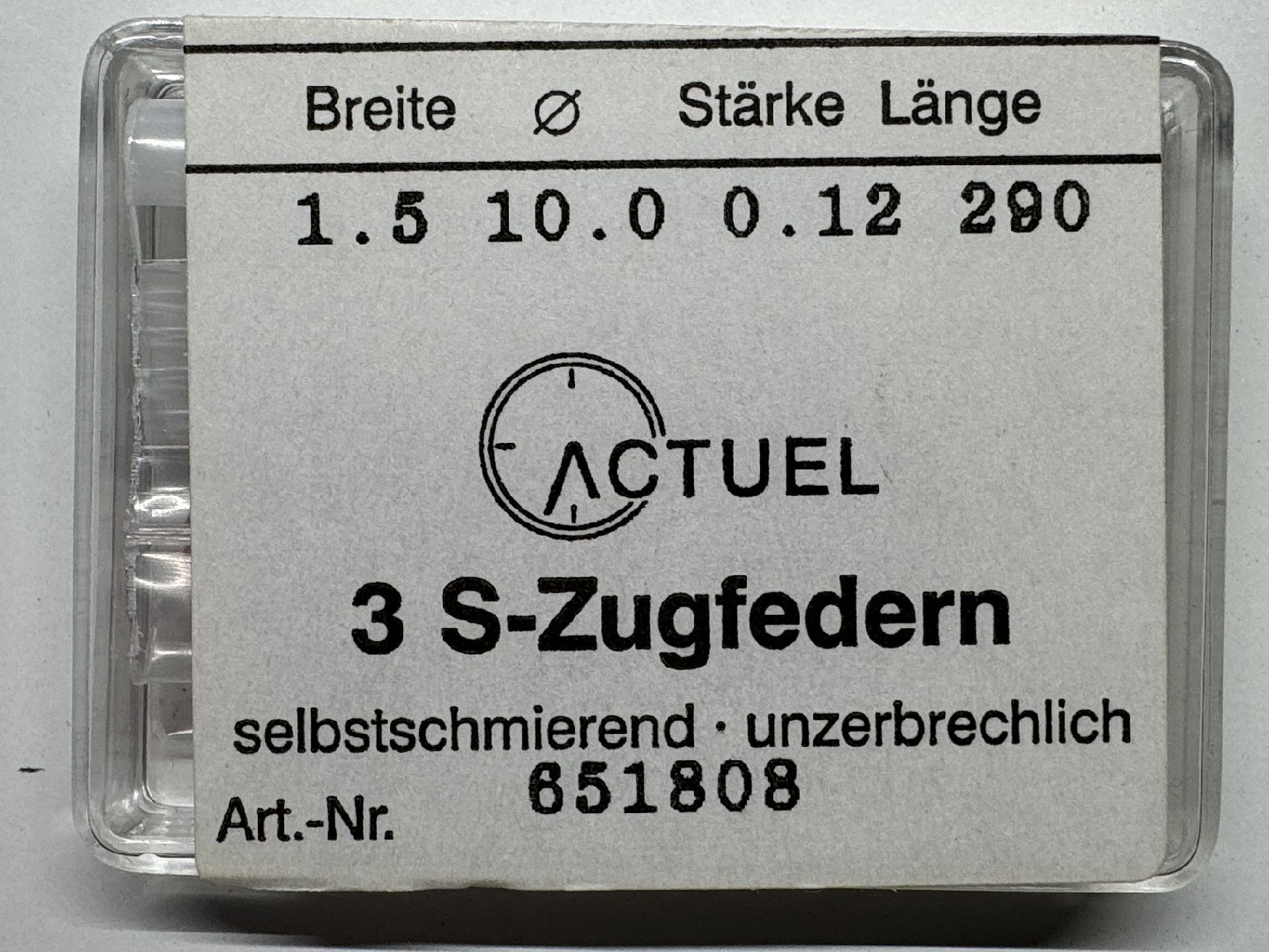 Verpackung mit drei silberfarbenen S-Zugfedern für Uhren.