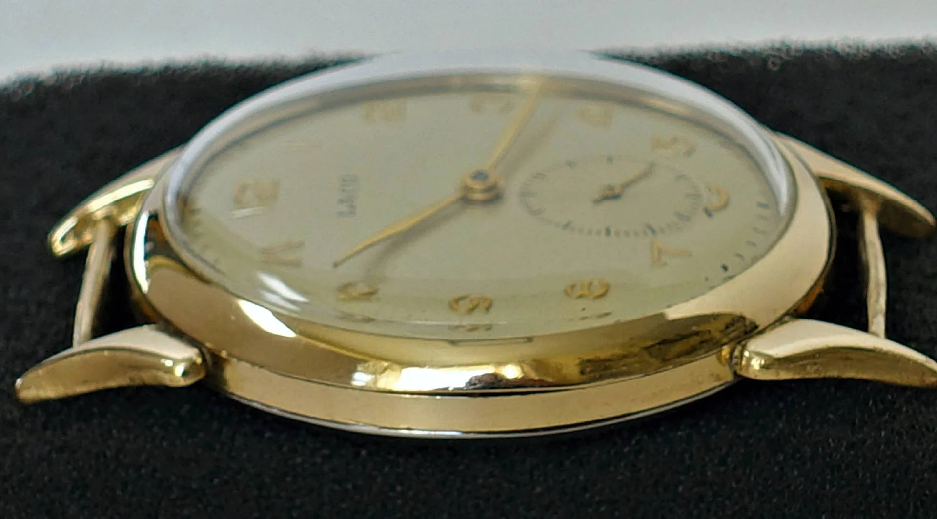 Armbanduhr goldfarben Flache Armbanduhr mit goldfarbenem Gehäuse und hellem Zifferblatt.