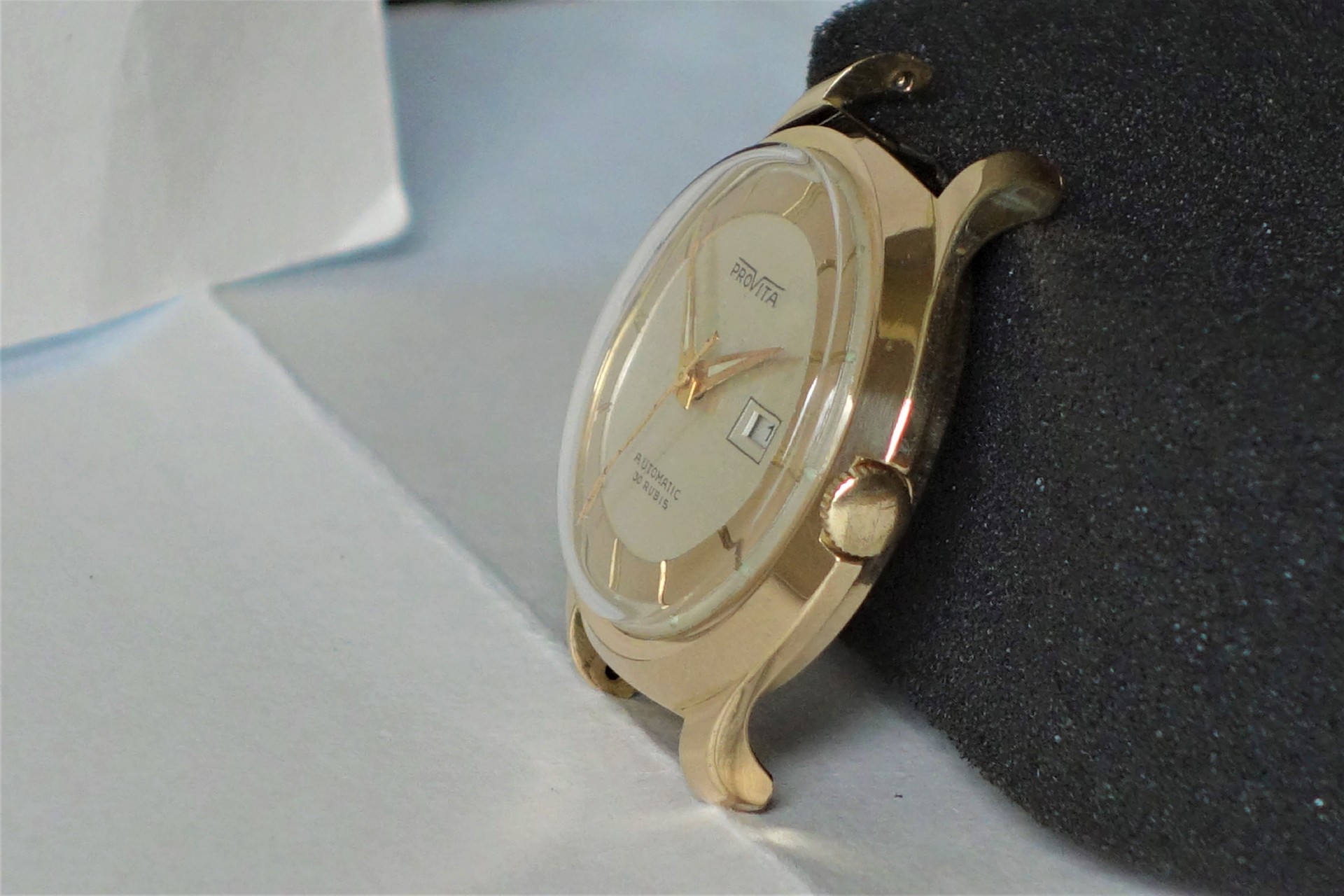 Goldfarbene Automatik-Armbanduhr mit hellem Zifferblatt und Datumsanzeige.