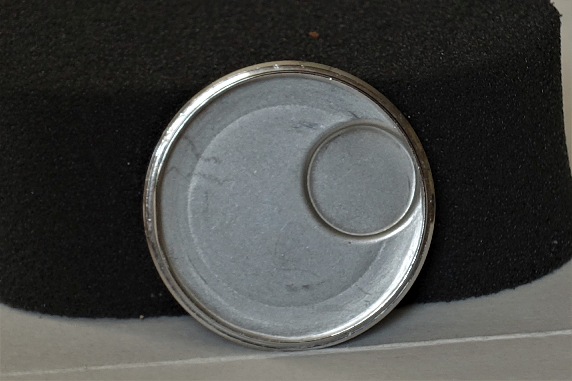 Runder silberfarbener Uhrenboden mit vertiefter Fläche.