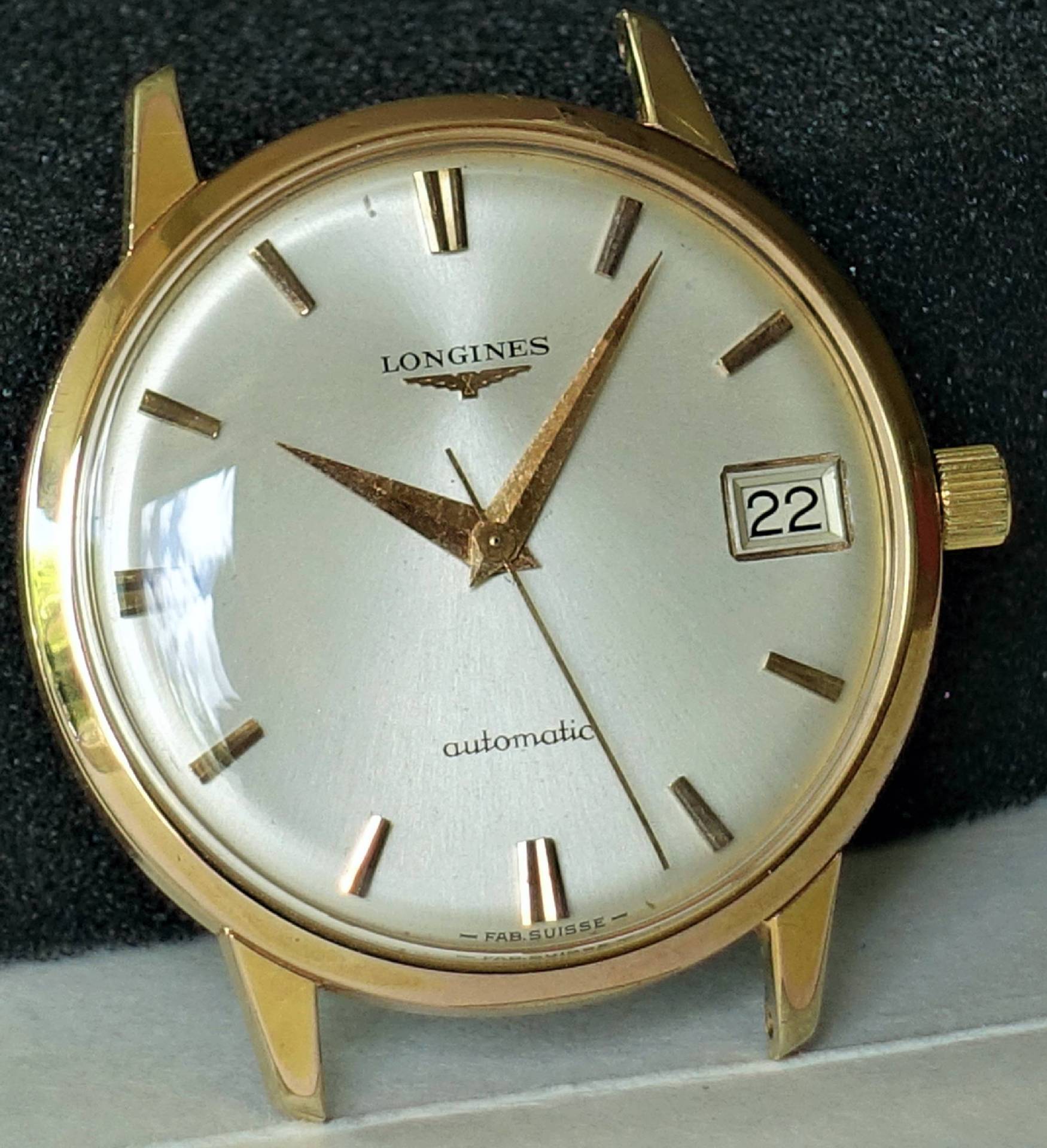 Goldfarbene Armbanduhr mit silbernem Zifferblatt und Datumsanzeige.