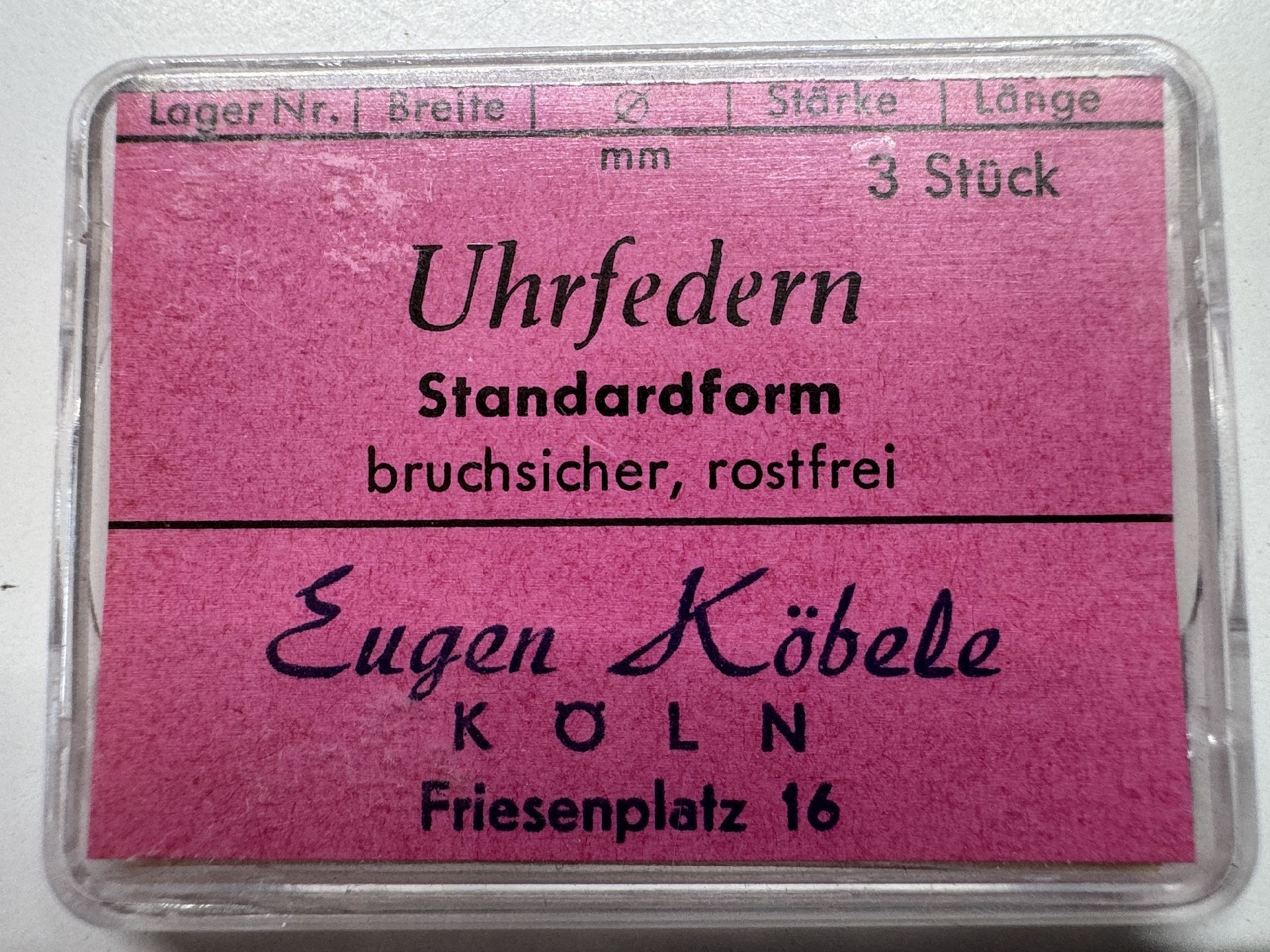 Set mit drei bruchsicheren, rostfreien Uhrfedern in einer transparenten Kunststoffbox mit pinkem Etikett.