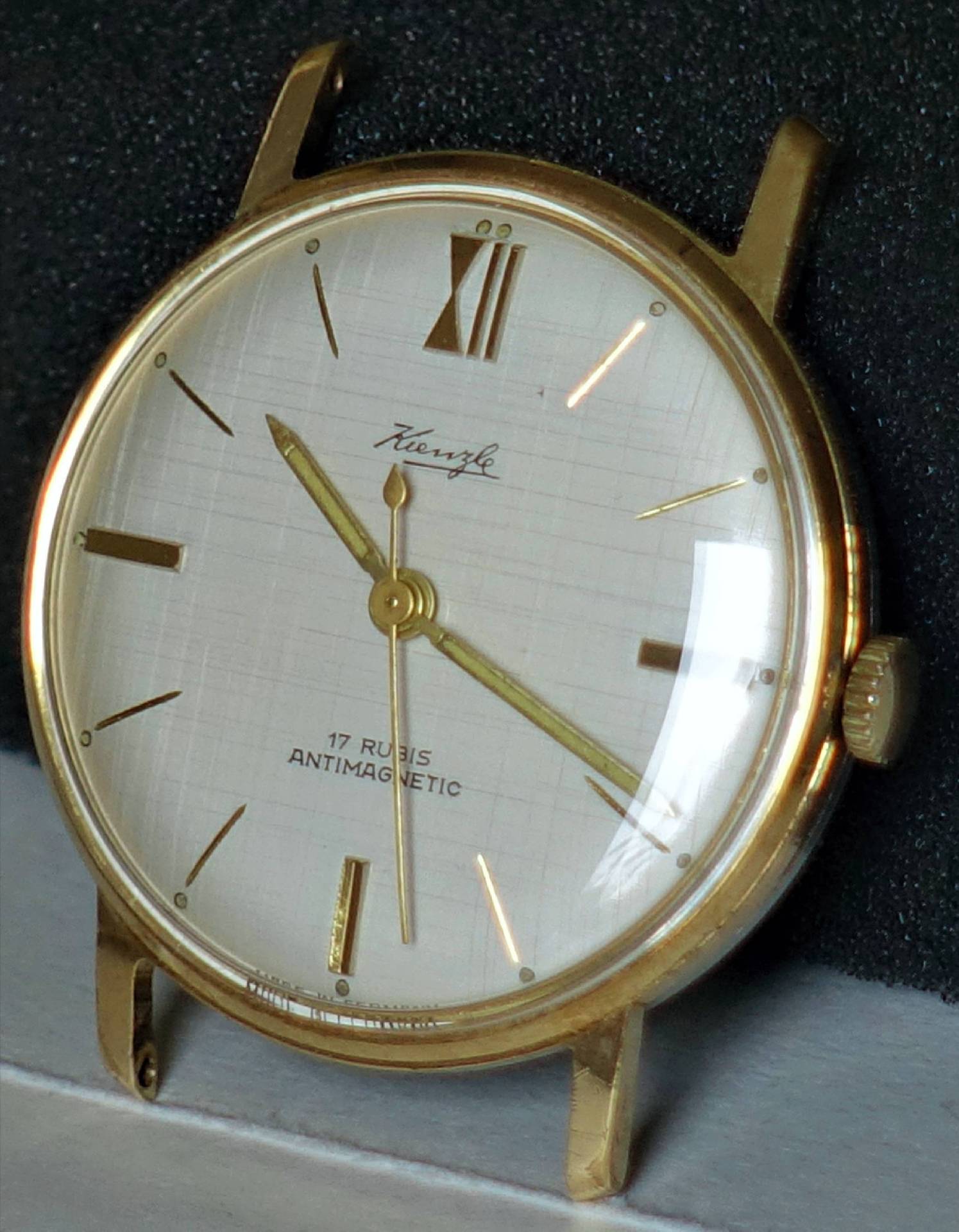 Goldfarbene Armbanduhr mit hellem Zifferblatt und goldenen Zeigern.