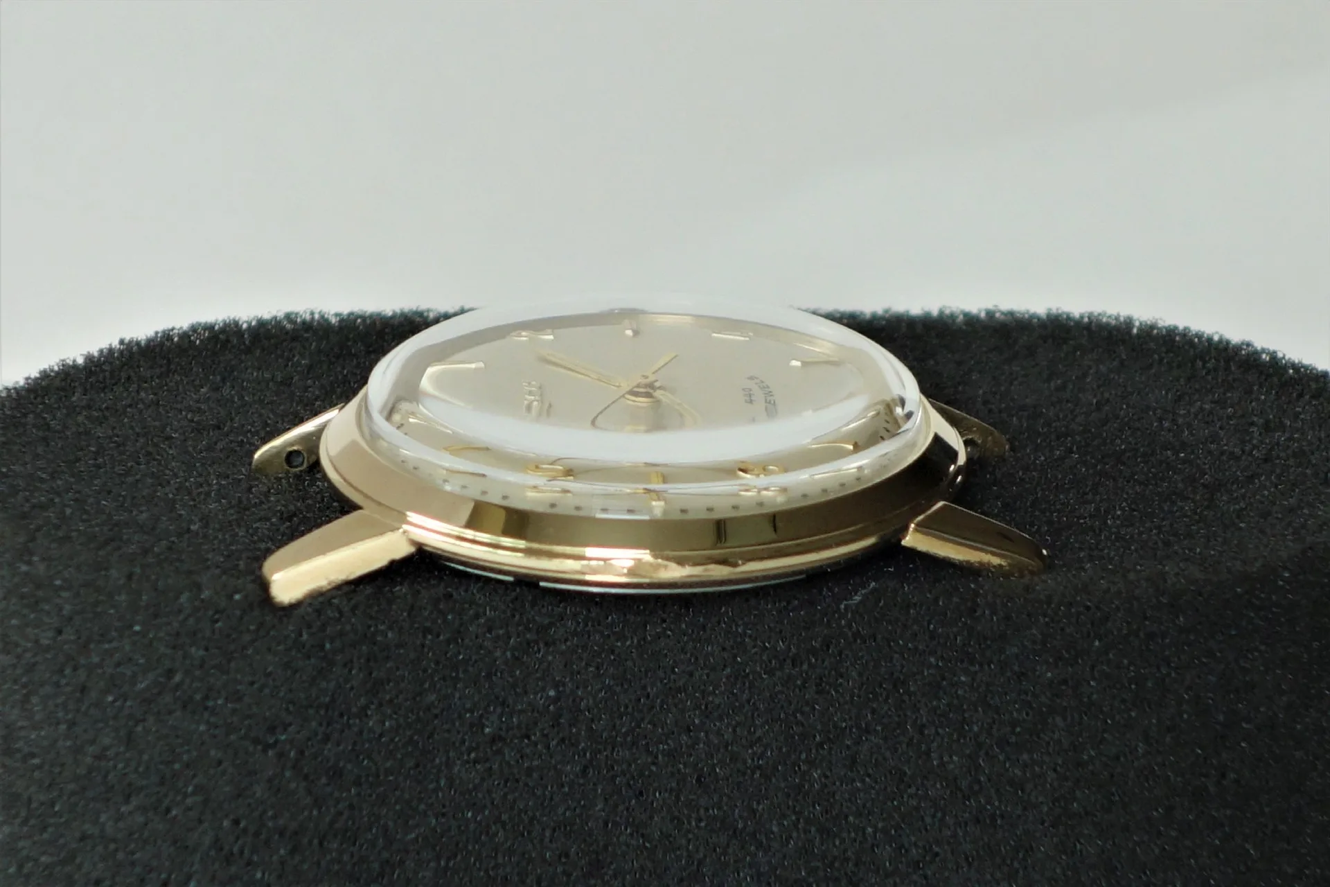 Uhrgehäuse goldfarben Goldfarbenes Uhrgehäuse mit Zifferblatt und Zeigern, ohne Armband.