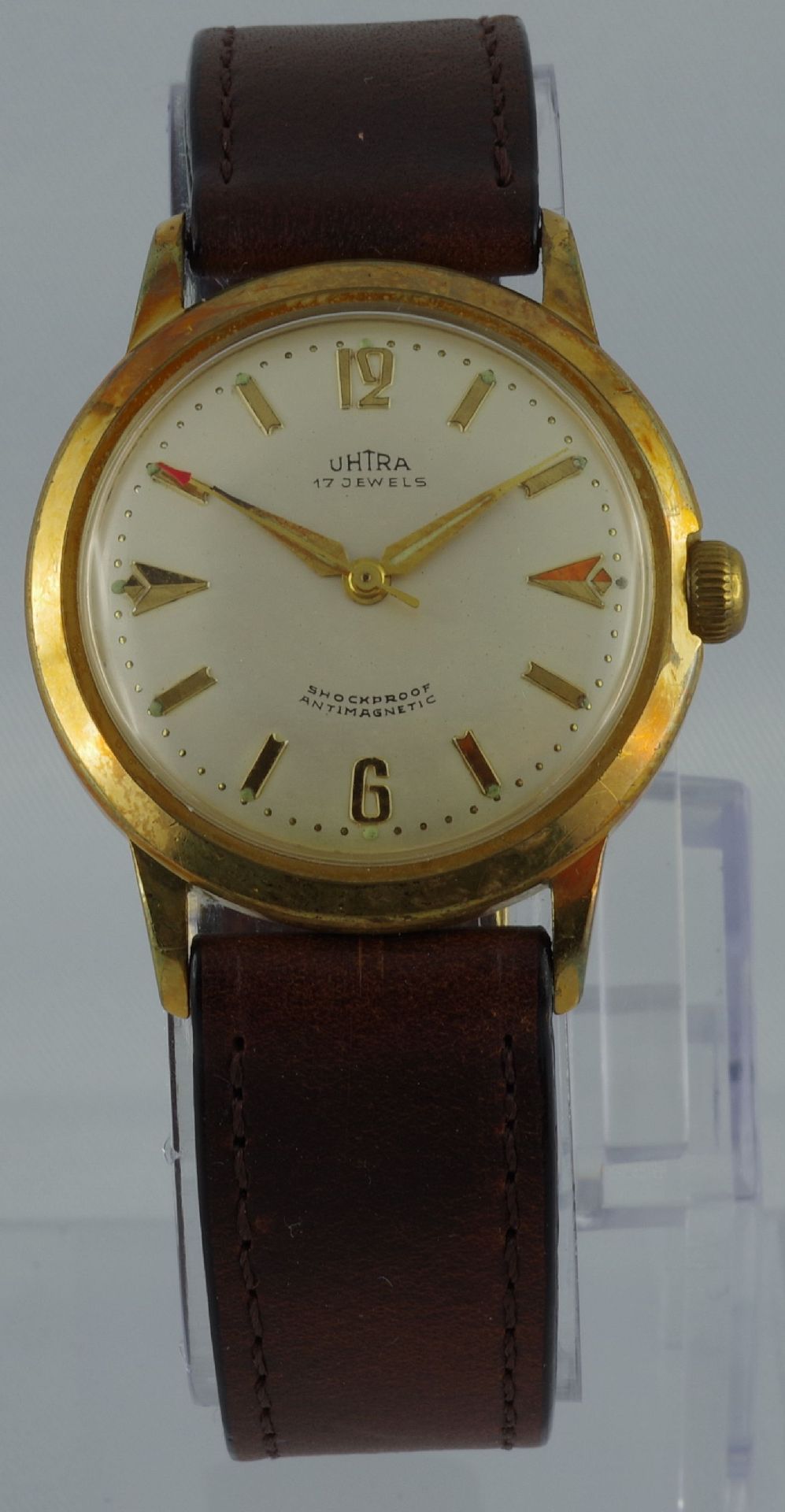 Analoge Armbanduhr mit goldfarbenem Gehäuse und braunem Lederarmband.