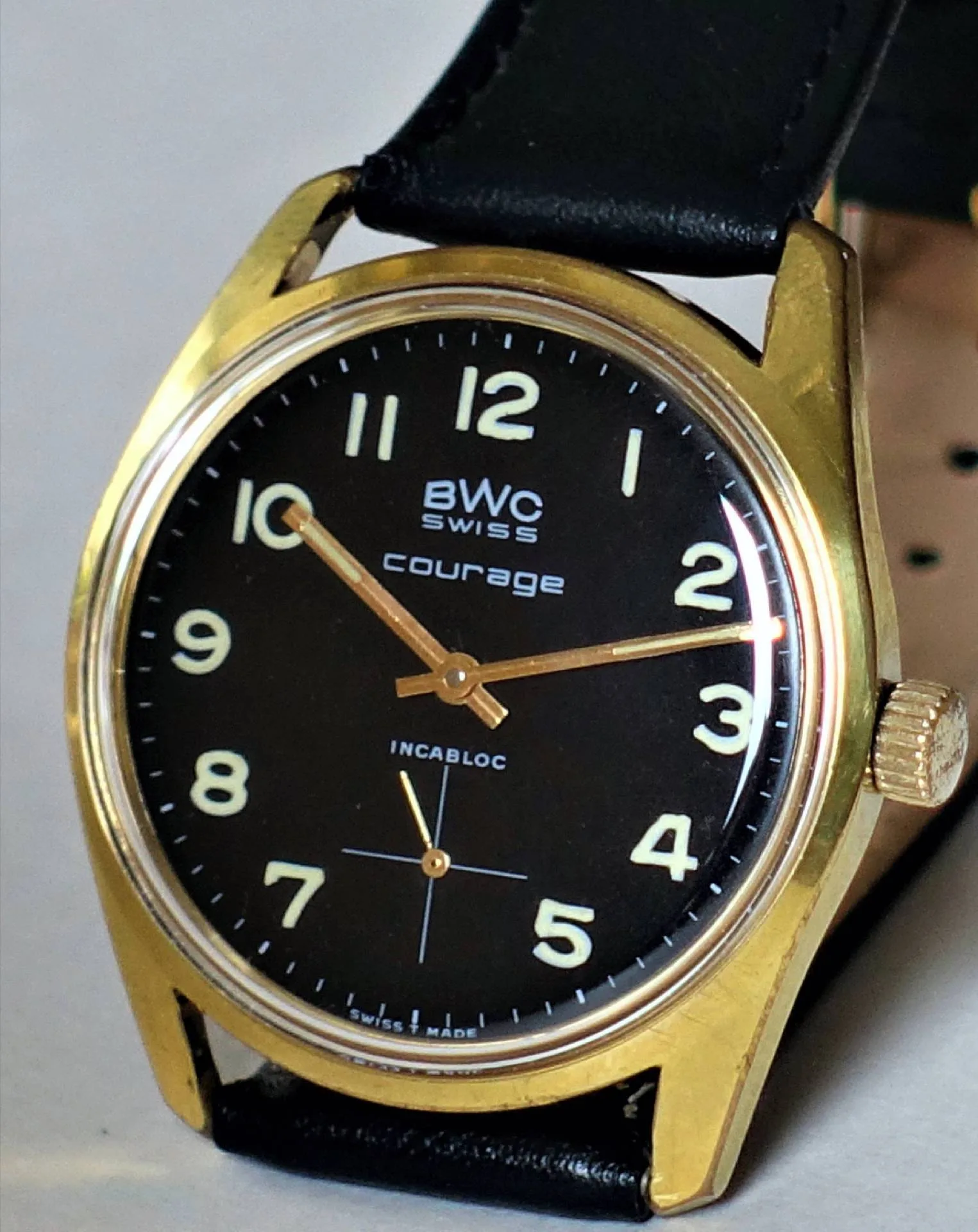Armbanduhr schwarz goldfarben Schwarze Armbanduhr mit goldfarbenem Gehäuse und schwarzem Lederarmband.