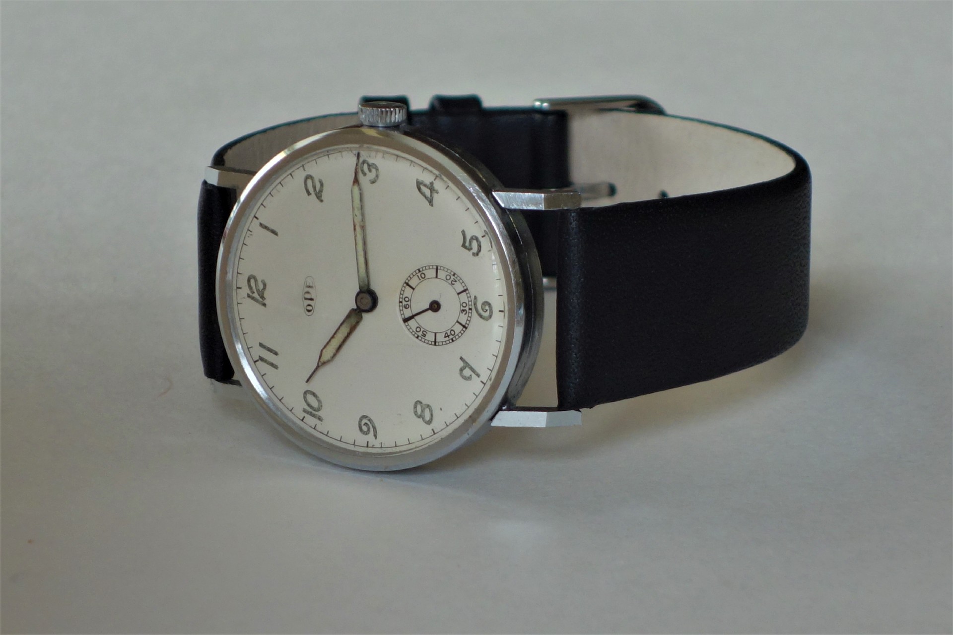 Silberfarbene Armbanduhr mit weißem Zifferblatt und schwarzem Armband.