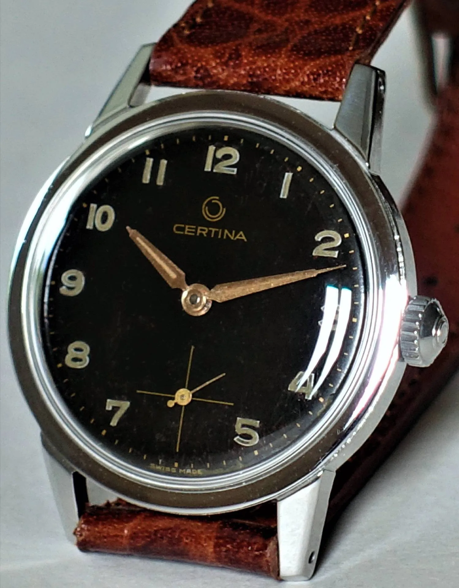 Certina Armbanduhr schwarz Schwarze Certina Armbanduhr mit silberfarbenem Gehäuse und braunem Armband.