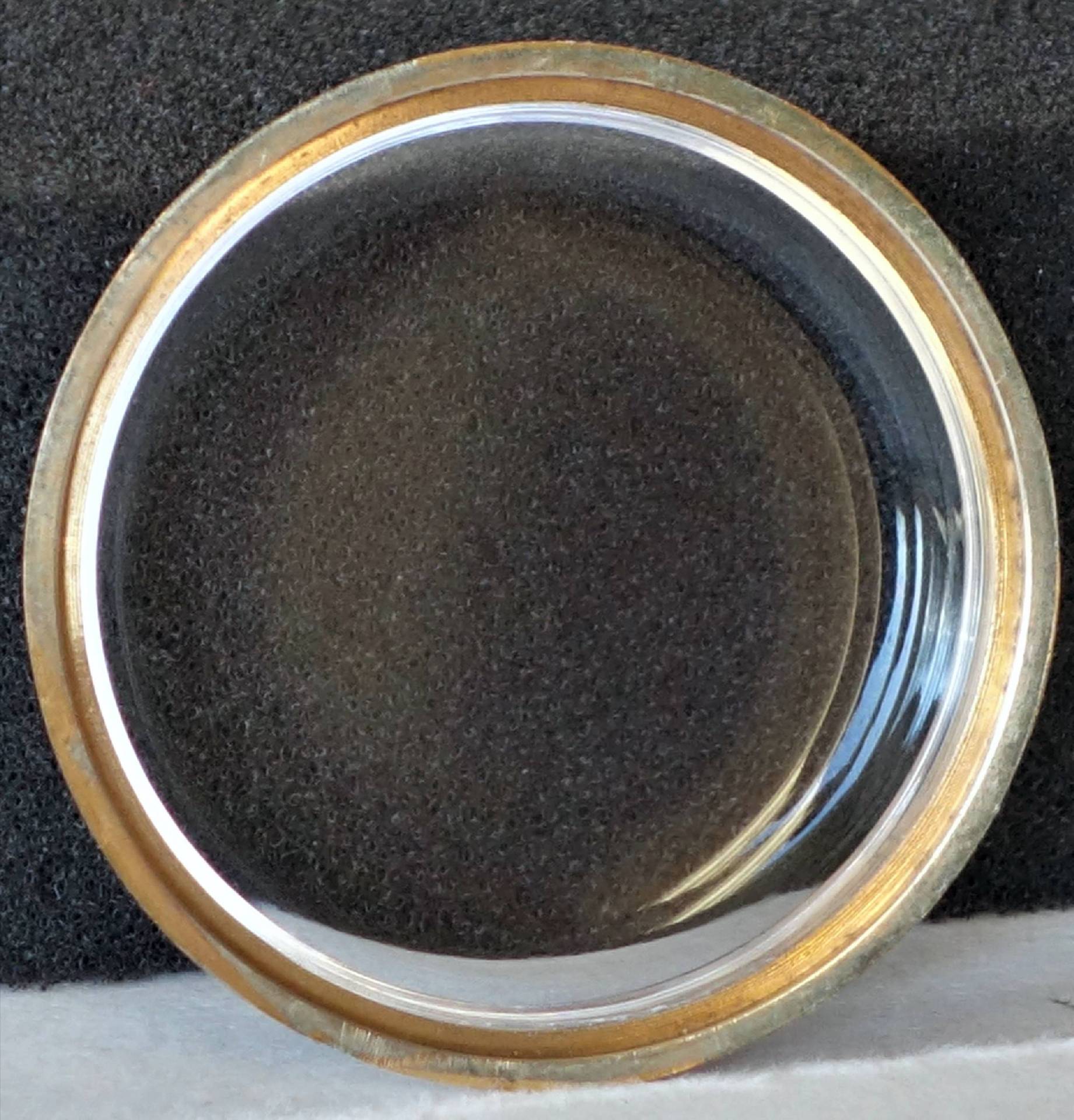 Transparentes Uhrglas mit Metallrand für Armbanduhren.