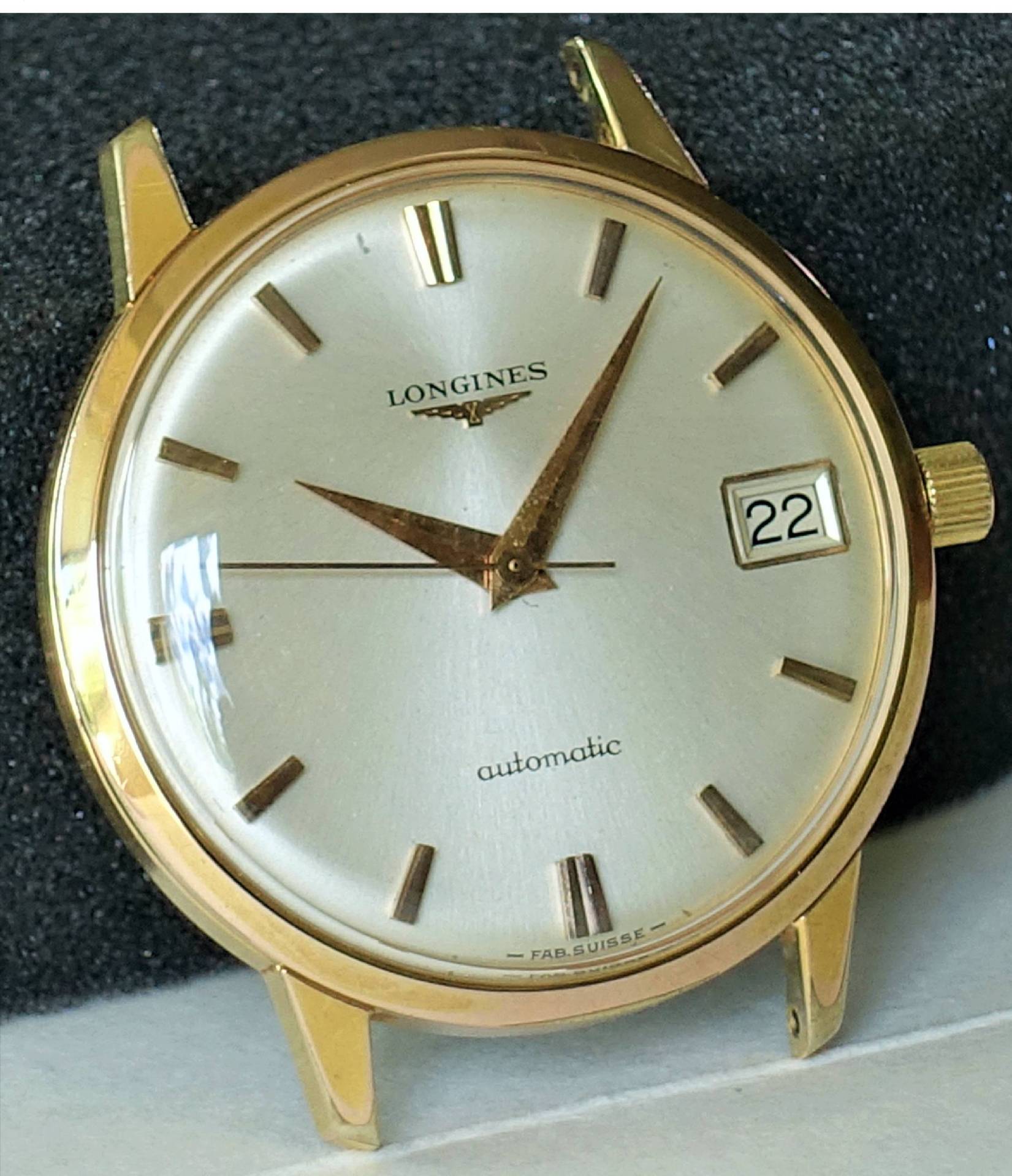 Goldfarbene Armbanduhr mit silbernem Zifferblatt, Datumsanzeige und Automatikaufzug.
