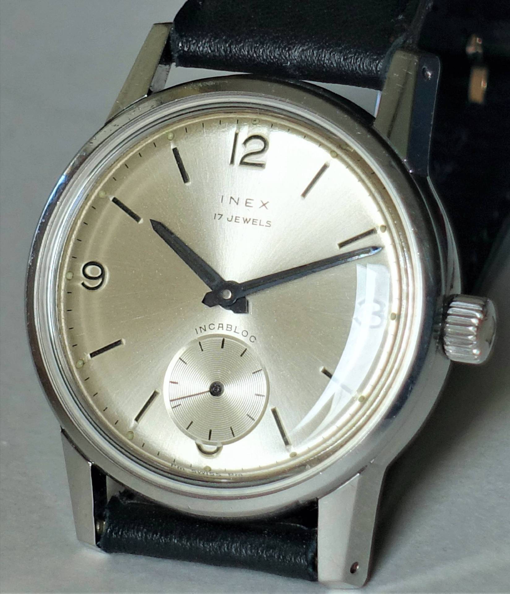 Detailansicht einer INEX Armbanduhr mit 17 Jewels auf schwarzem Lederarmband