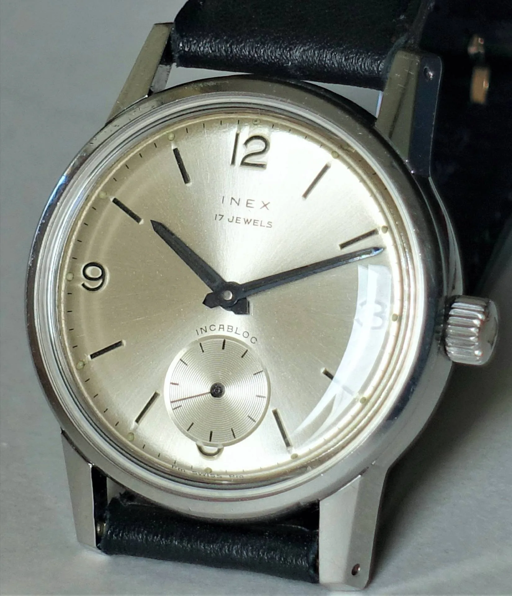 Detailansicht einer INEX Armbanduhr mit 17 Jewels auf schwarzem Lederarmband