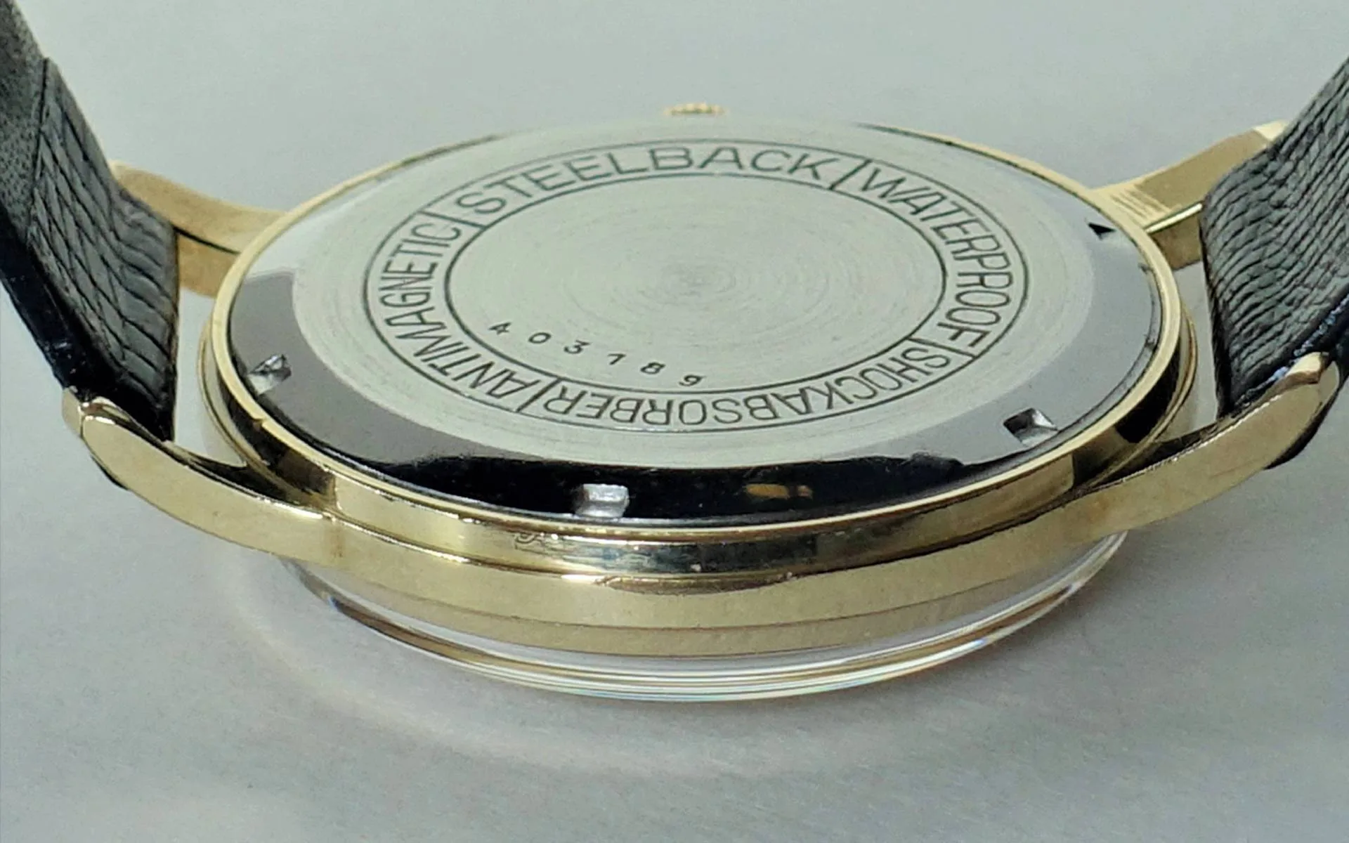 Uhrboden silberfarben Silberfarbener Uhrboden mit Gravur und schwarzem Lederarmband.