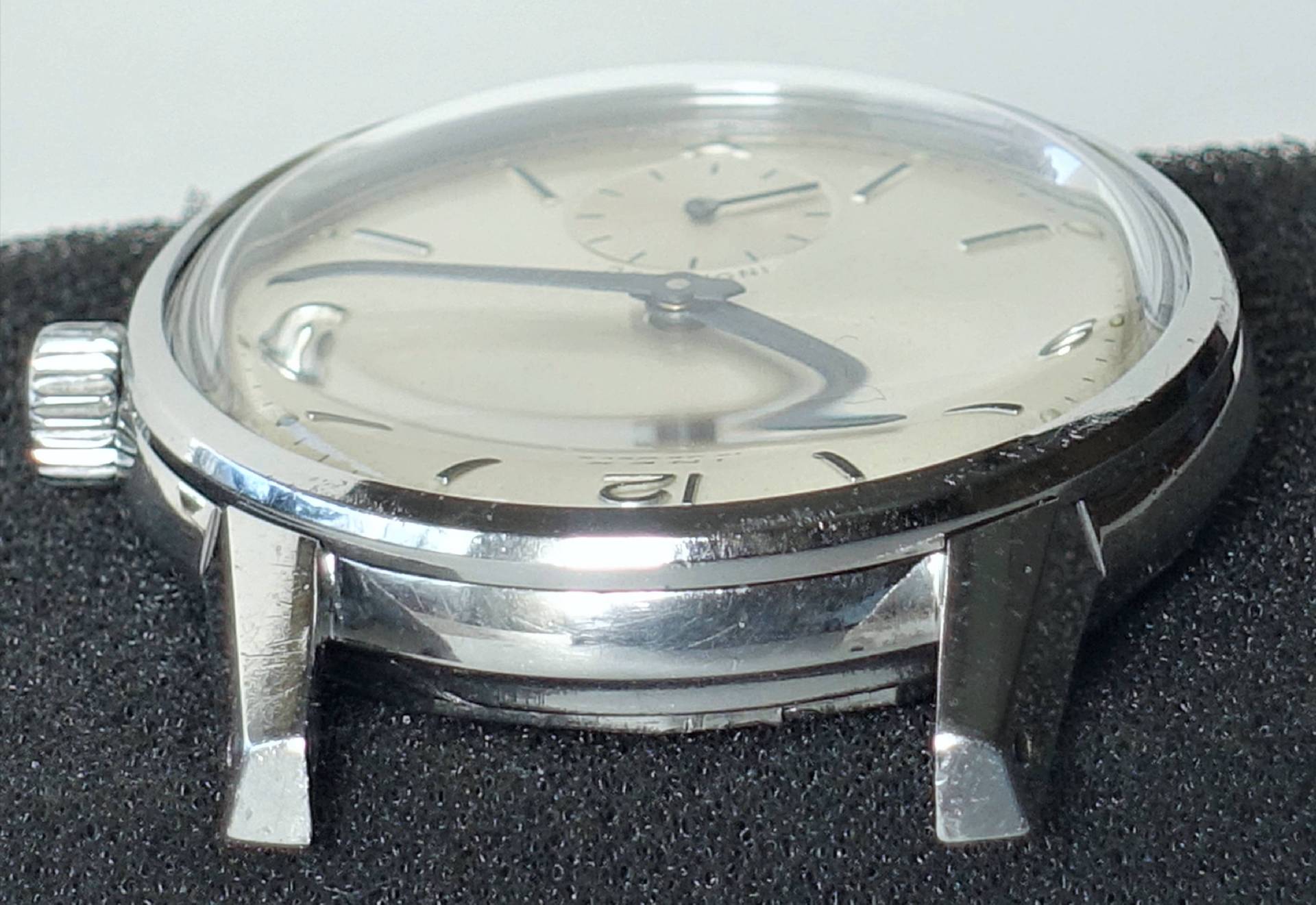 Detailansicht einer eleganten Armbanduhr mit silbernem Zifferblatt und Edelstahlgehäuse