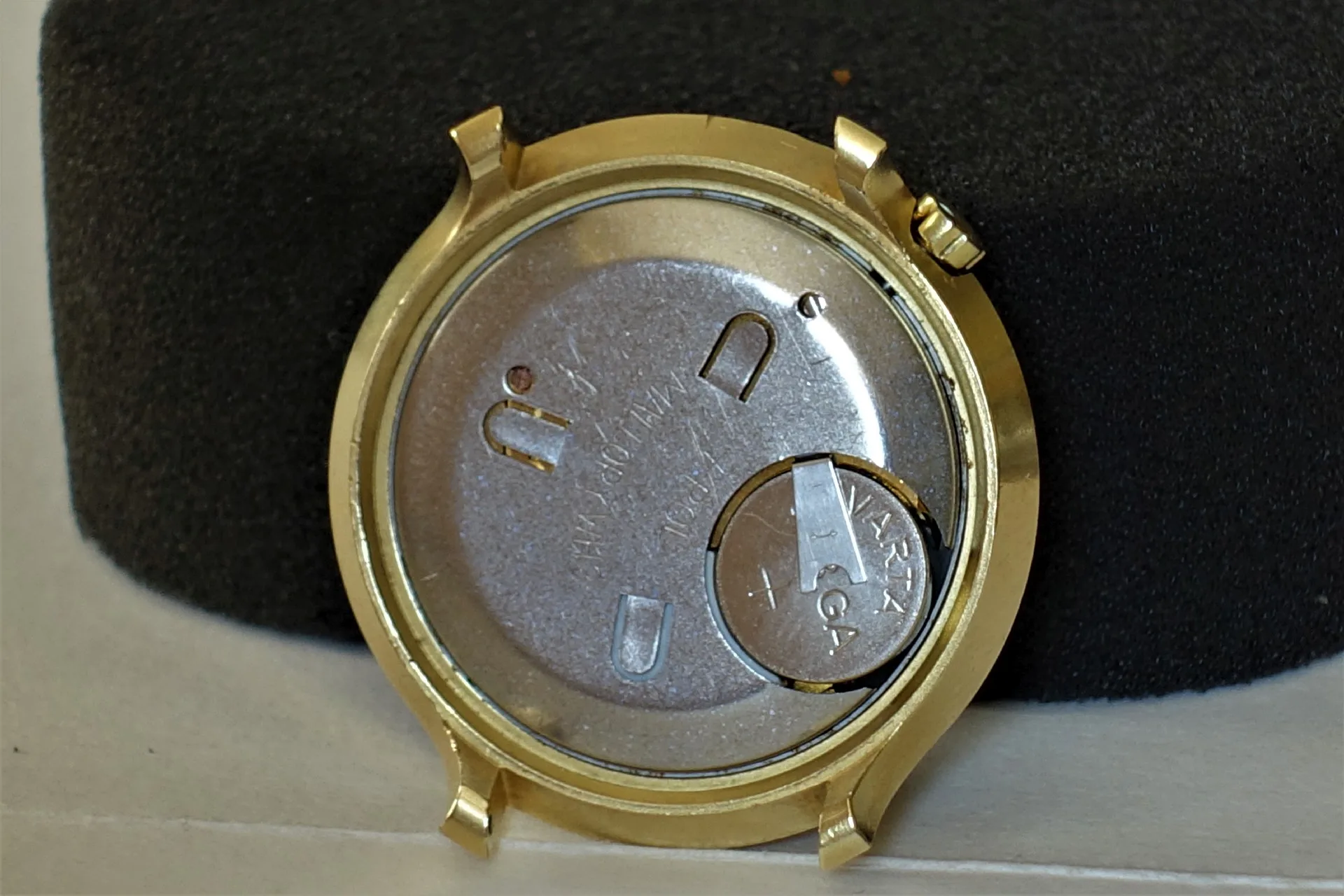 Quarzuhrwerk goldfarben Rückseite eines goldfarbenen Quarzuhrwerks mit eingesetzter Knopfzellenbatterie.
