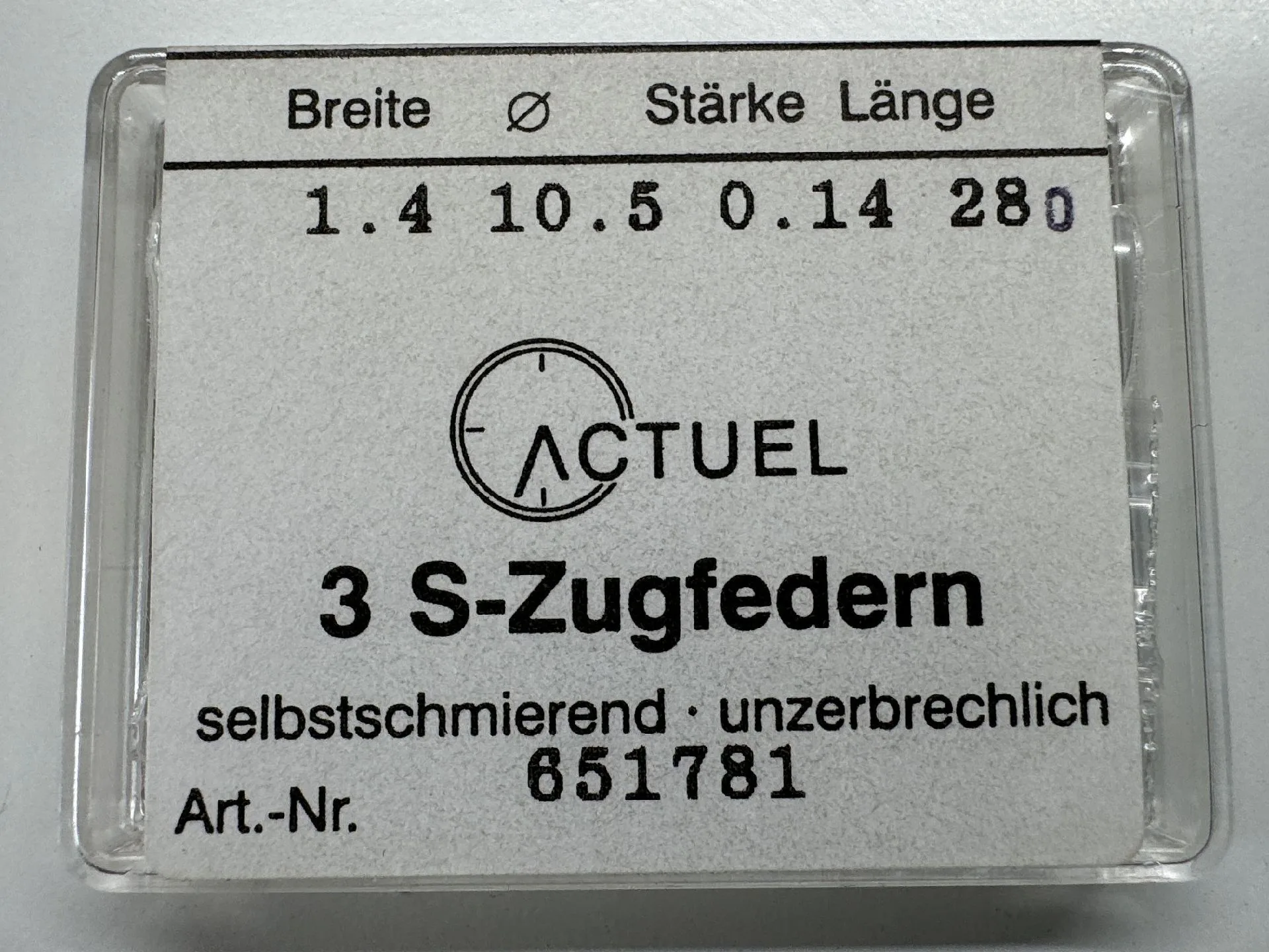 Zugfeder Set Set mit drei silberfarbenen Zugfedern für Uhren in transparenter Verpackung.