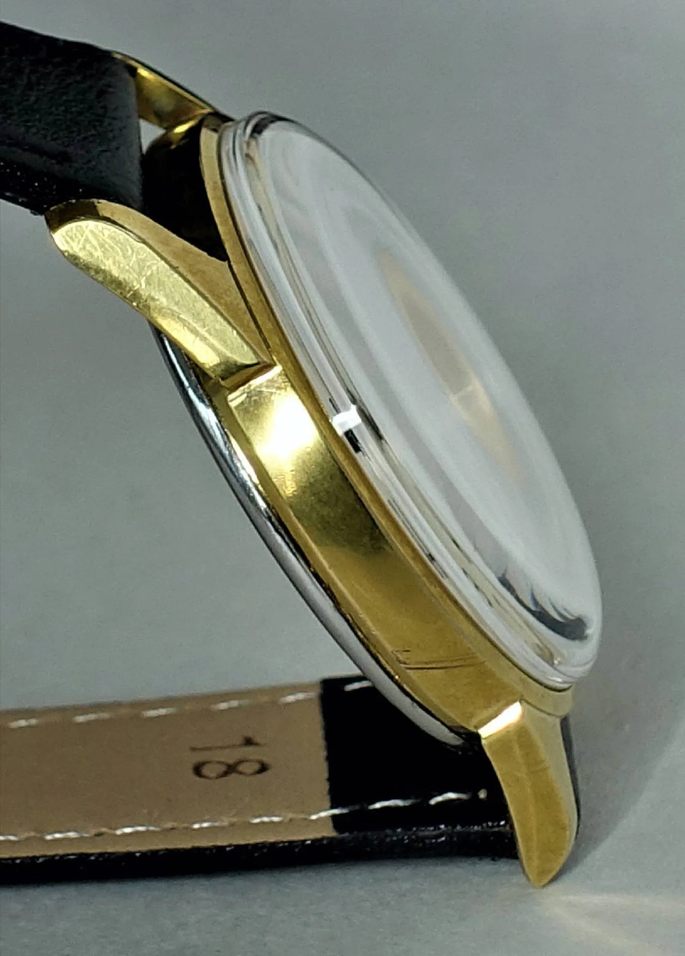 Armbanduhr Gehäuse goldfarben Gehäuse einer Armbanduhr in goldfarbener Optik mit schwarzem Lederarmband.