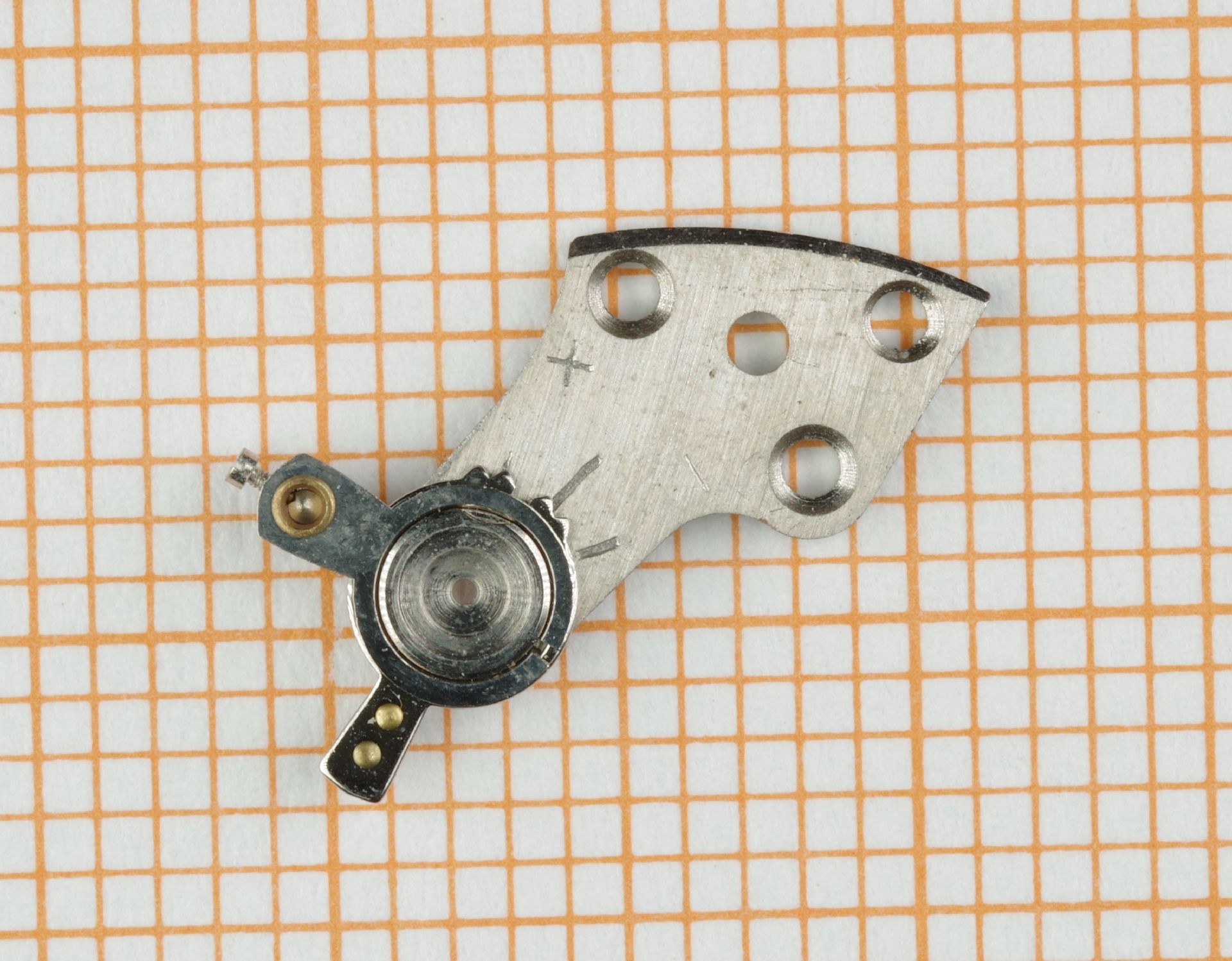 Metallene Brücke eines Uhrwerks mit mehreren Bohrungen und Lager.