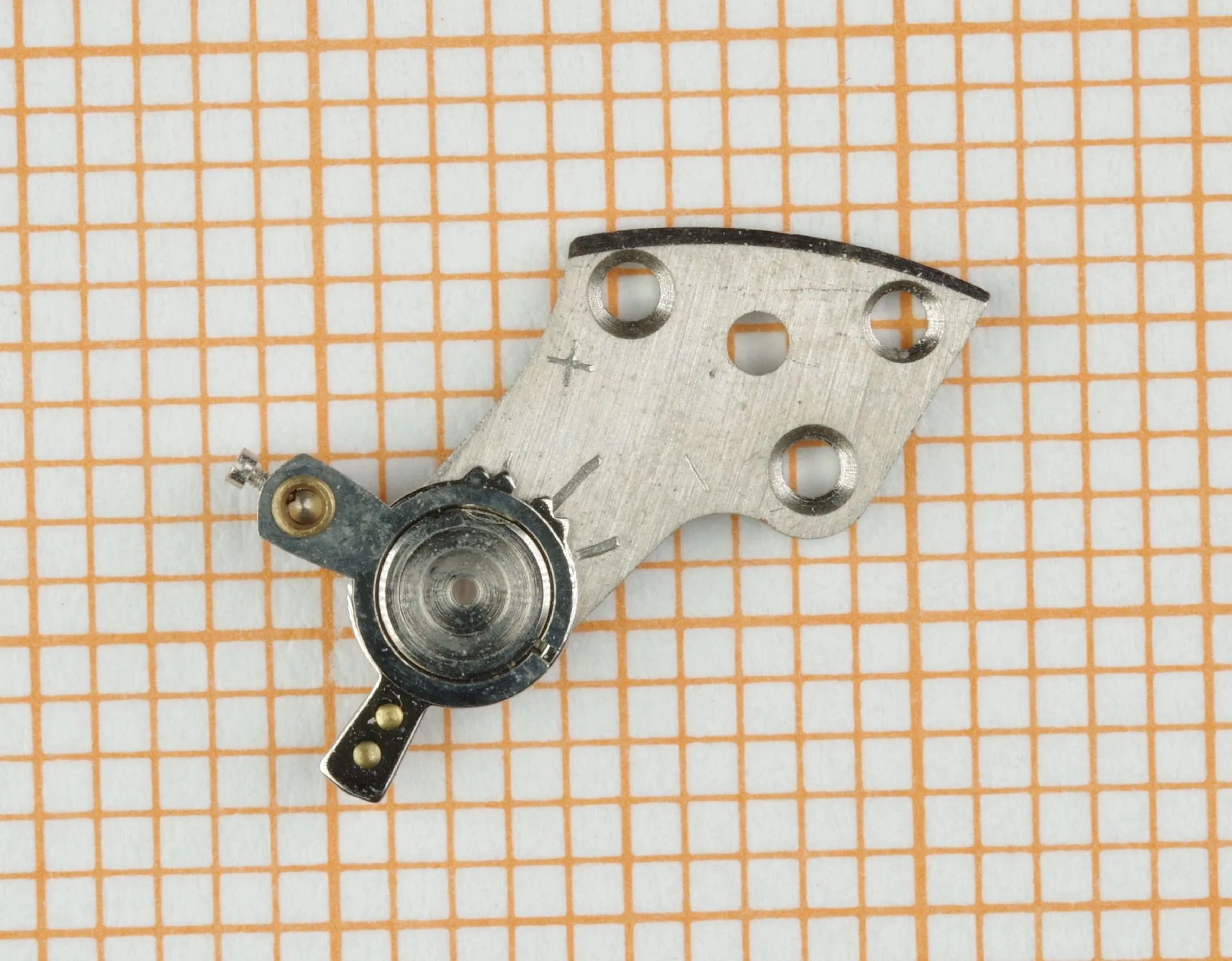 Metallene Brücke eines Uhrwerks mit mehreren Bohrungen und Lager.