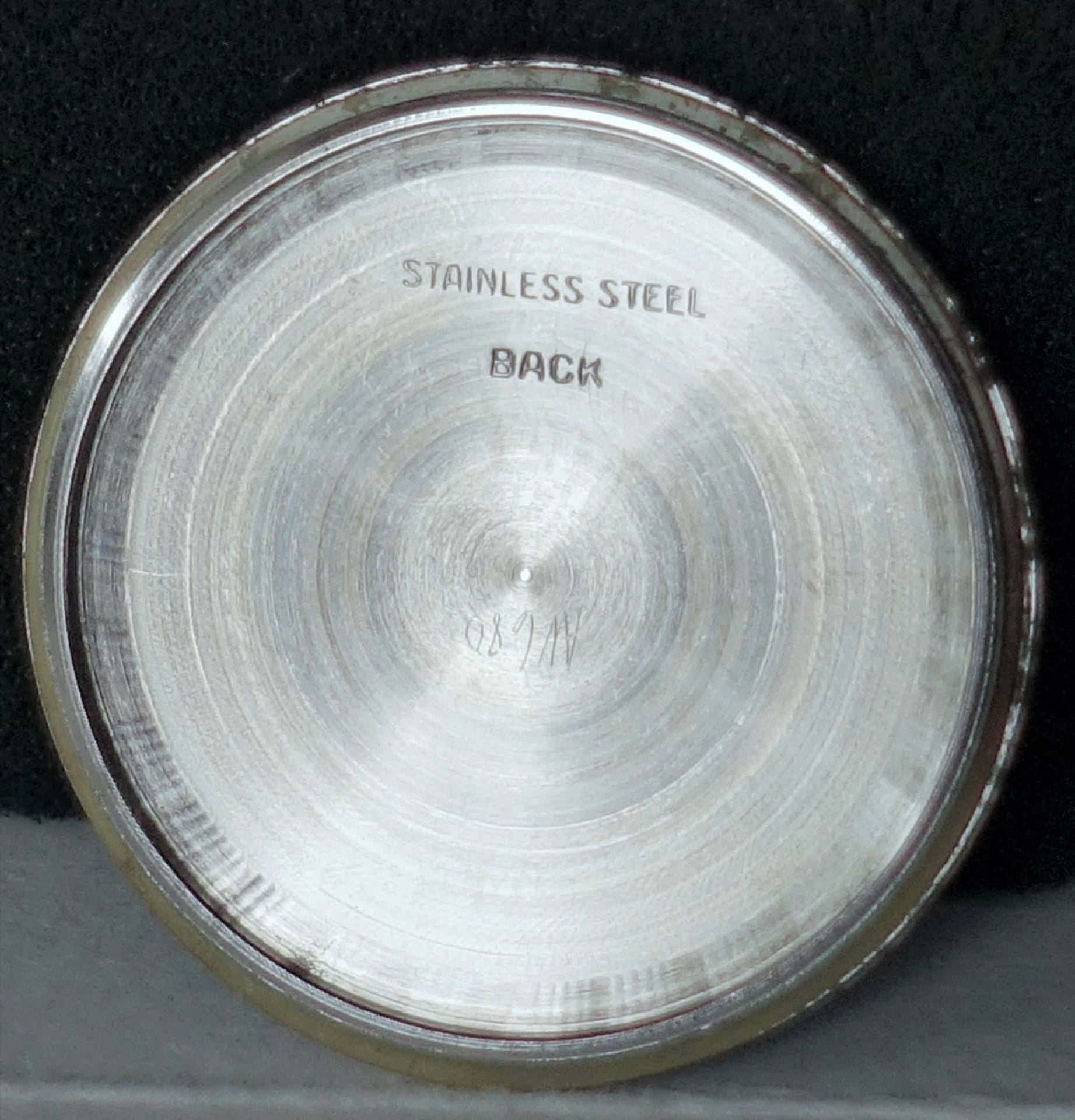 Runder silberfarbener Gehäuseboden aus Metall mit Gravur "Stainless Steel Back".