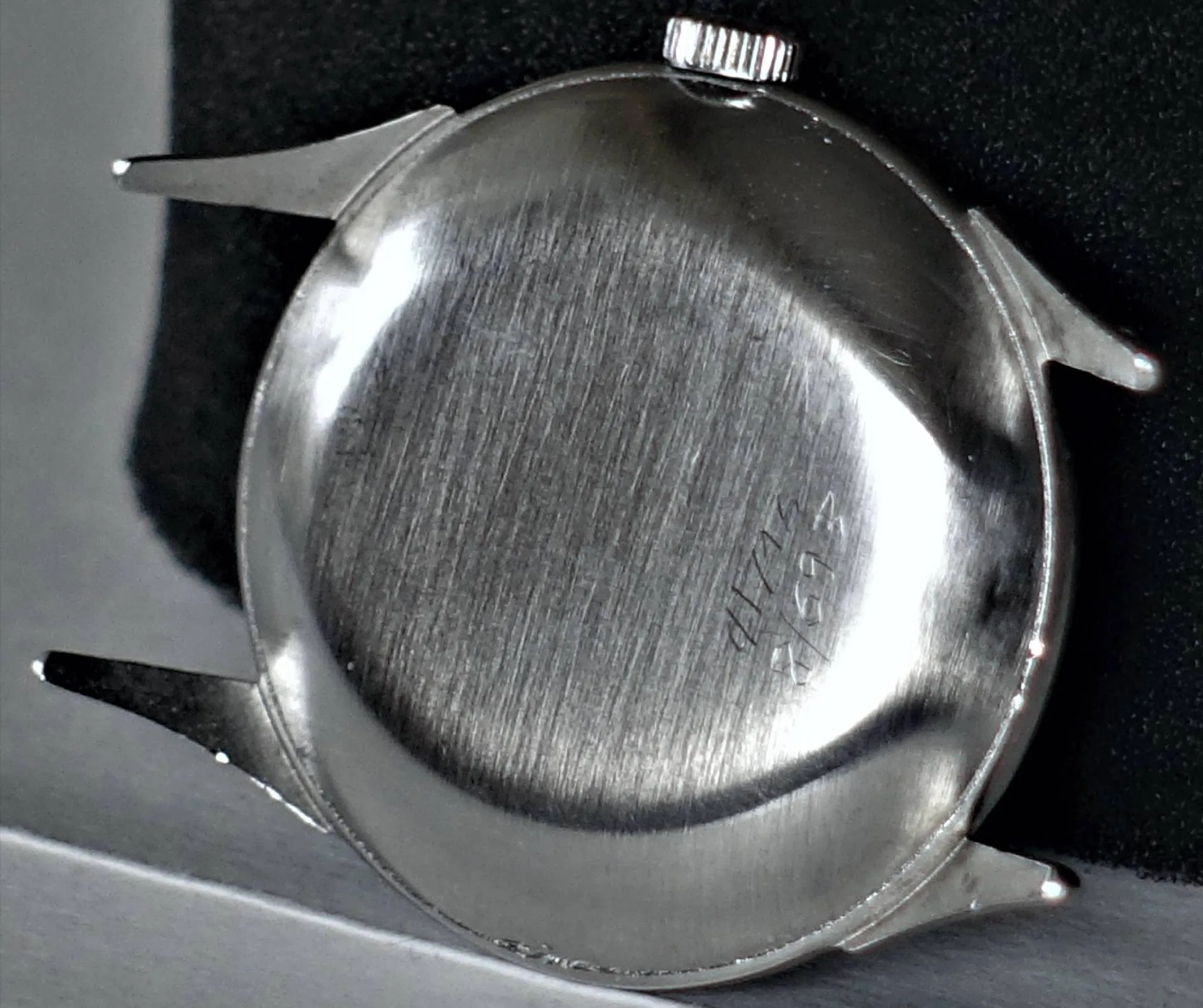 Silbernes Uhrgehäuse ohne Band Rückseite eines silberfarbenen Uhrgehäuses mit sichtbarer Gravur und ohne montiertes Armband.