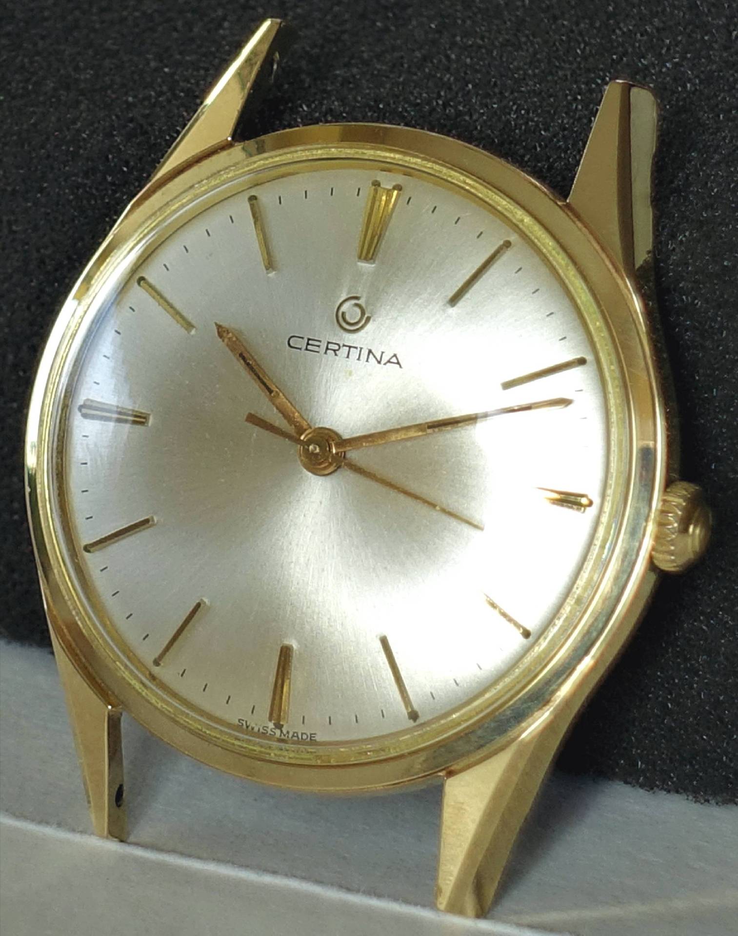 Goldfarbene Certina Armbanduhr mit silberfarbenem Zifferblatt und goldenen Zeigern.