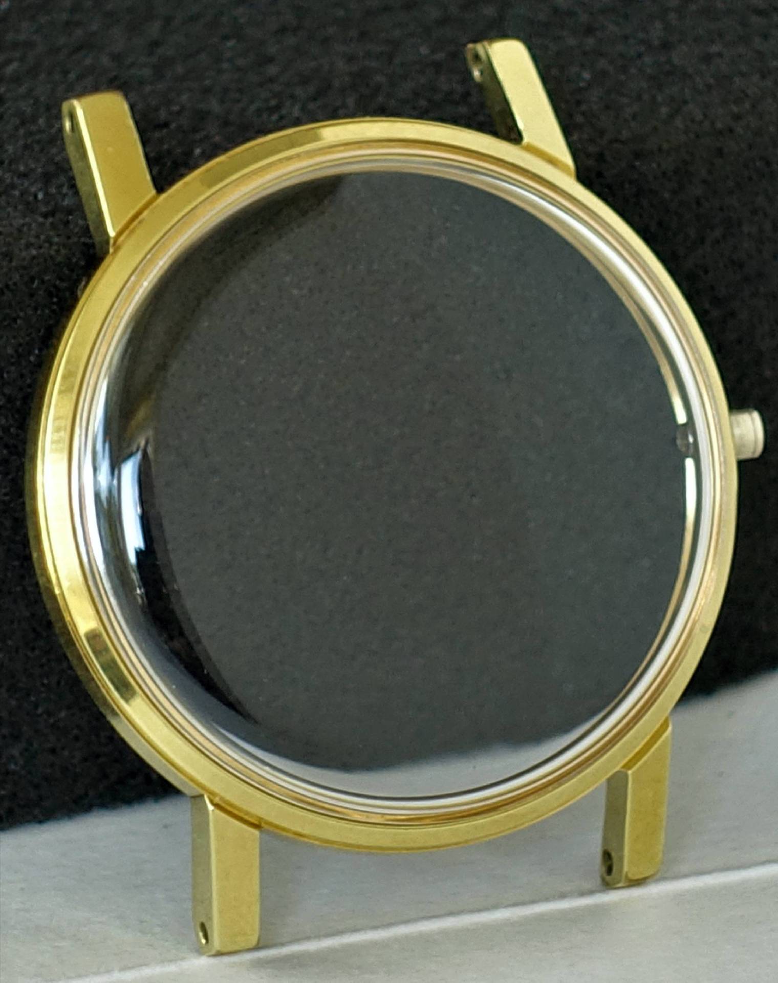 Rundes Uhrengehäuse in goldfarbener Ausführung mit transparentem Glas.