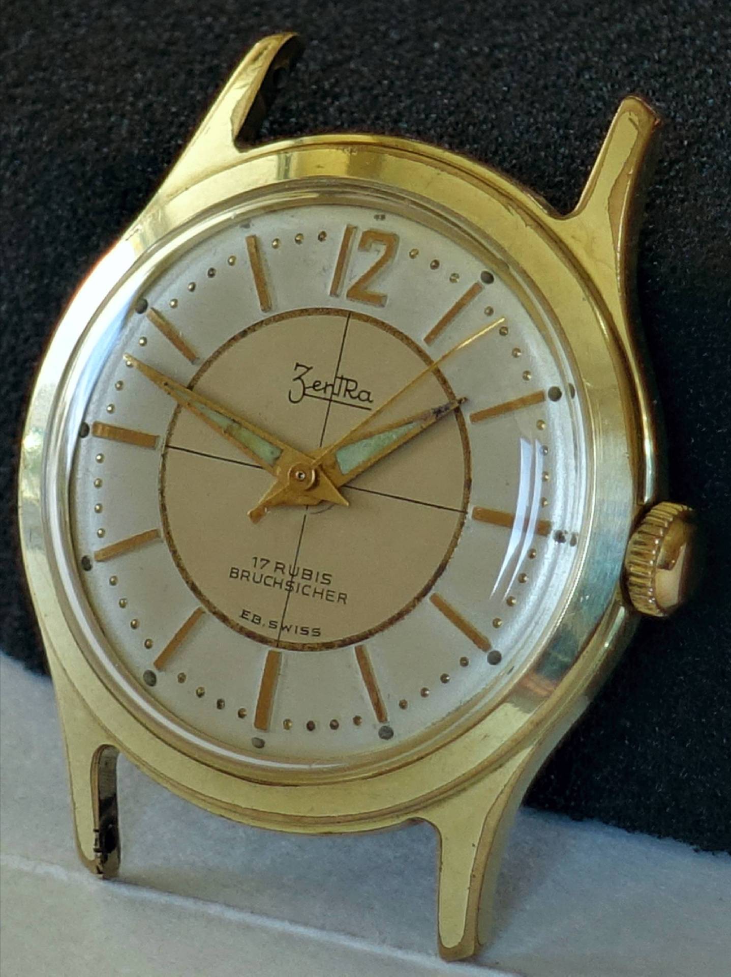 Goldfarbene Armbanduhr mit hellem Zifferblatt und goldenen Zeigern.