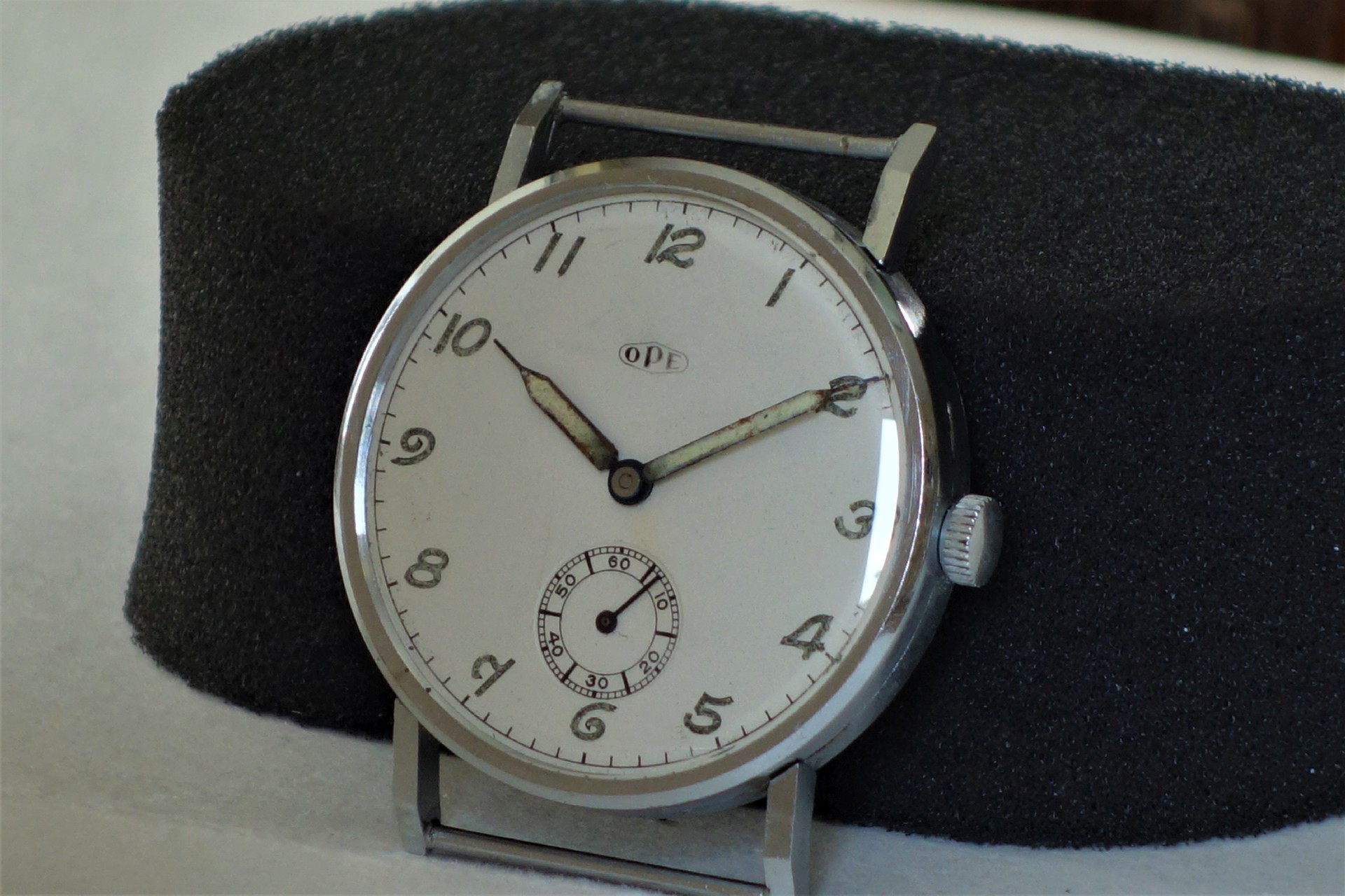 Runde mechanische Armbanduhr mit silberfarbenem Gehäuse und weißem Zifferblatt.