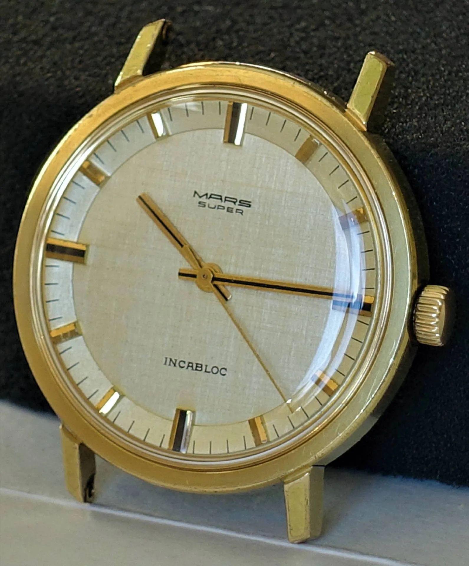 Mars Super Armbanduhr Goldfarbene Mars Super Armbanduhr mit hellem Zifferblatt und drei Zeigern.
