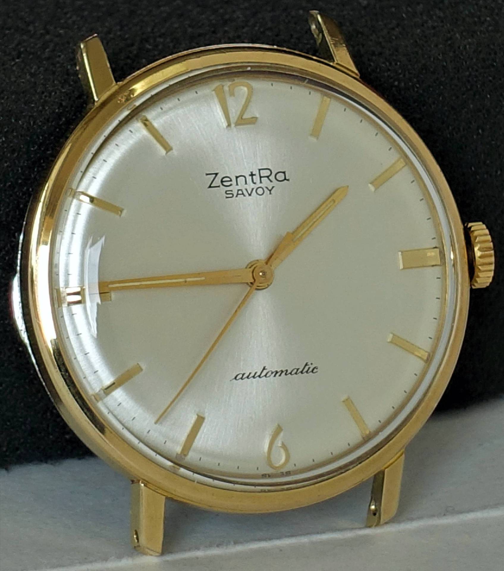 Goldfarbene Armbanduhr mit hellem Zifferblatt und goldenen Zeigern.