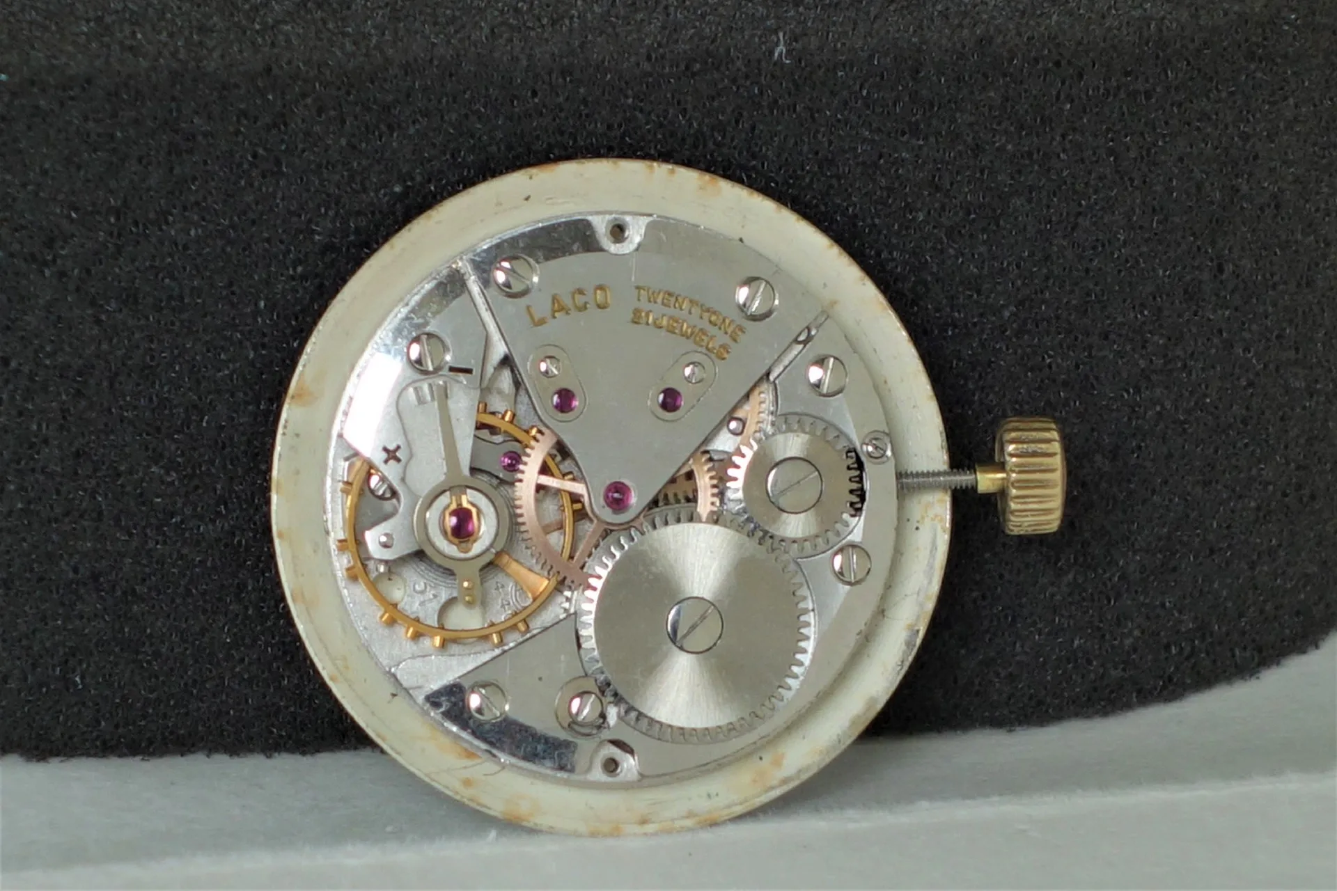 Silberfarbenes mechanisches Uhrwerk von Laco mit sichtbaren Zahnrädern und goldfarbener Krone.