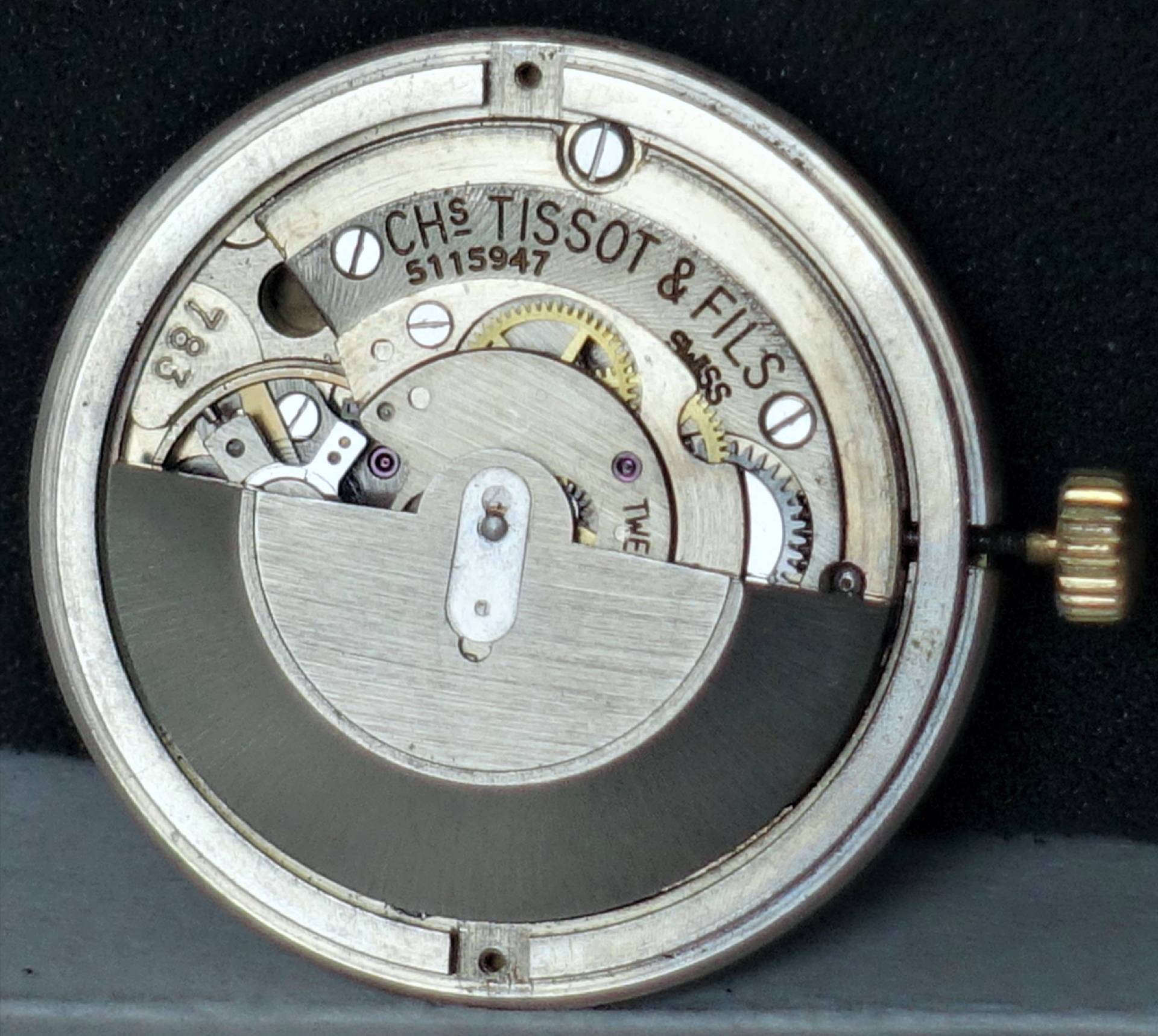 Silberfarbenes mechanisches Uhrwerk von Tissot mit sichtbaren Zahnrädern und Schwungmasse.