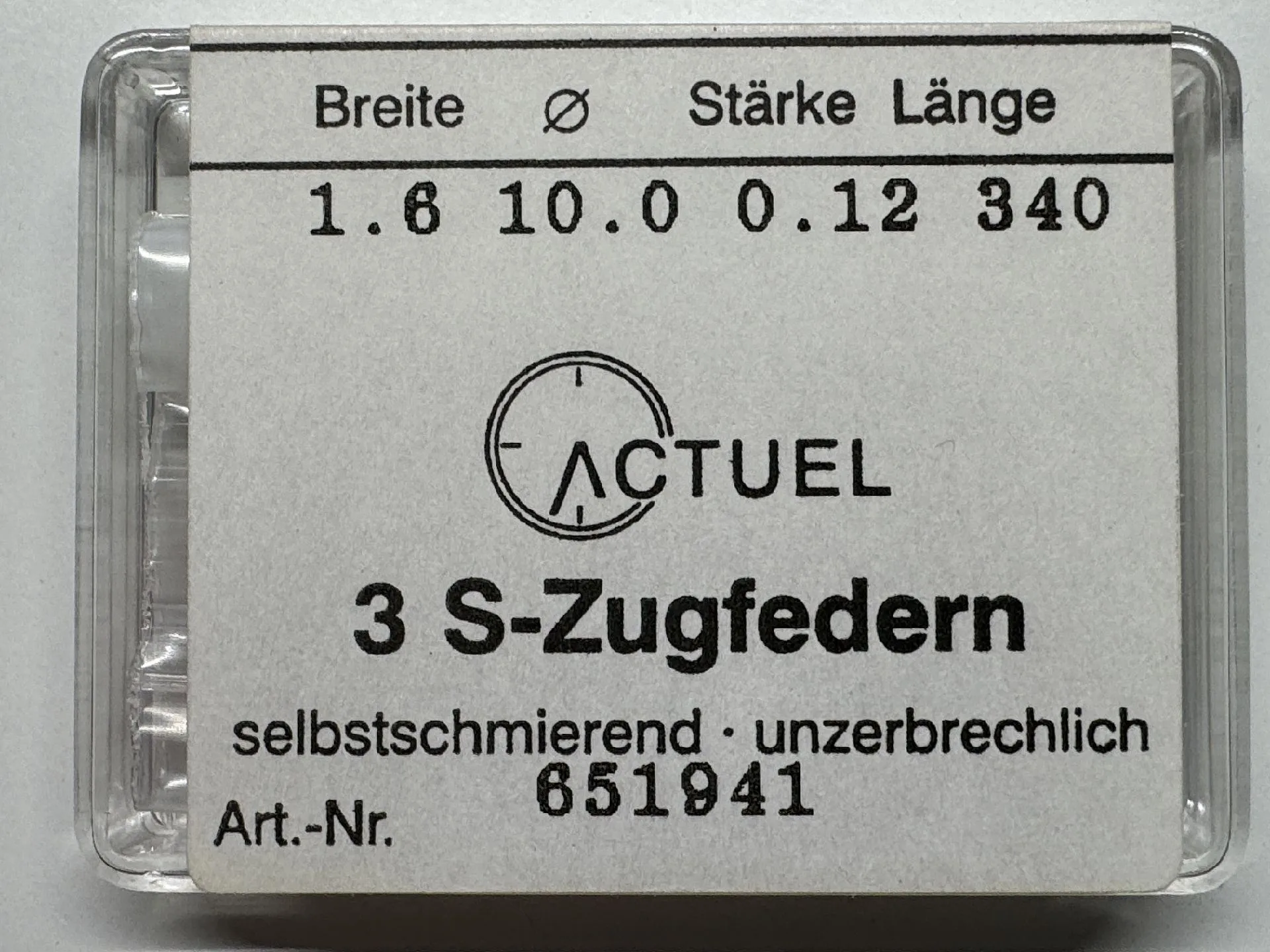 Drei silberfarbene Zugfedern für Uhrwerke in transparenter Verpackung.