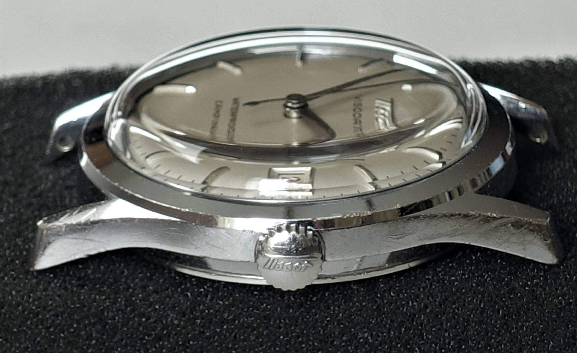 Silberfarbene Armbanduhr mit rundem Gehäuse, silbernem Zifferblatt und Datumsanzeige.