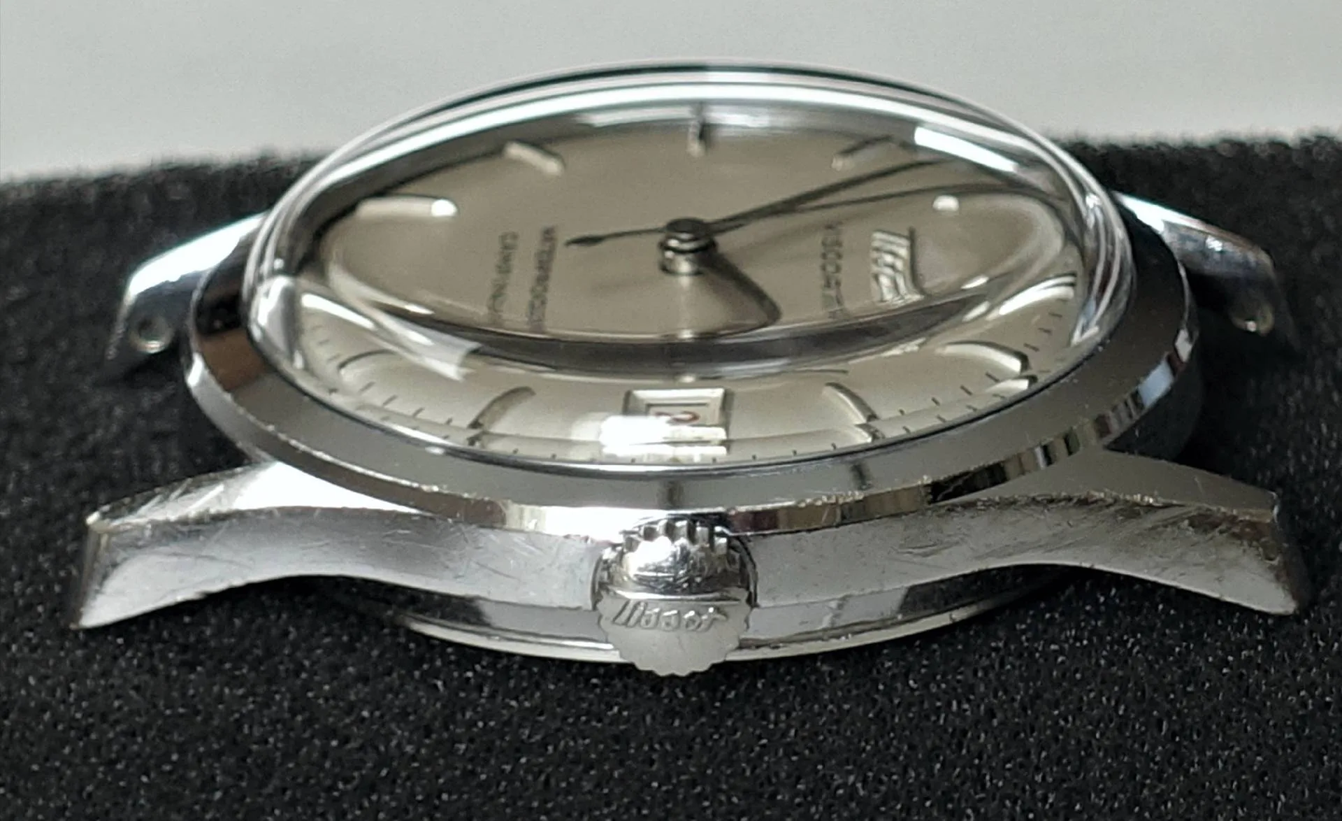Silberne Armbanduhr mit Datum Silberfarbene Armbanduhr mit rundem Gehäuse, silbernem Zifferblatt und Datumsanzeige.