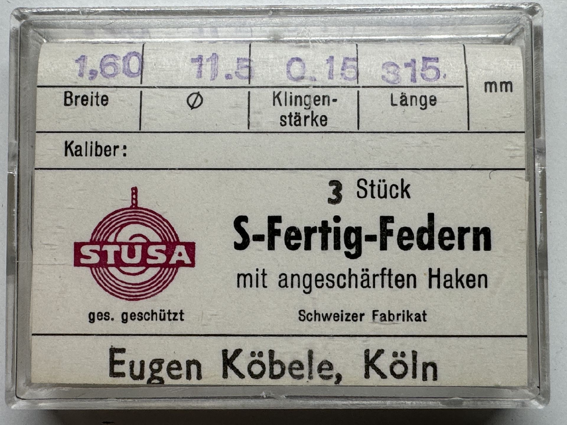 Set mit drei Uhrmacher-Federn mit angeschärften Haken in transparenter Kunststoffbox.