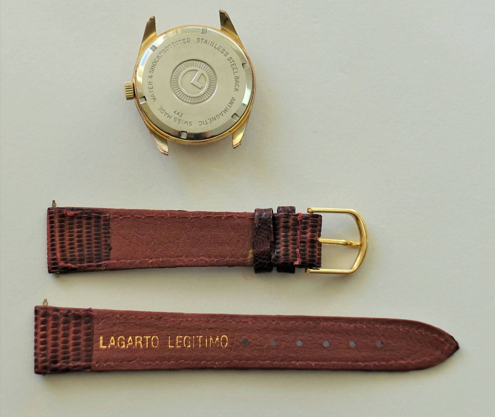 Goldfarbenes Uhrgehäuse mit braunem Lederarmband in zwei Teilen.