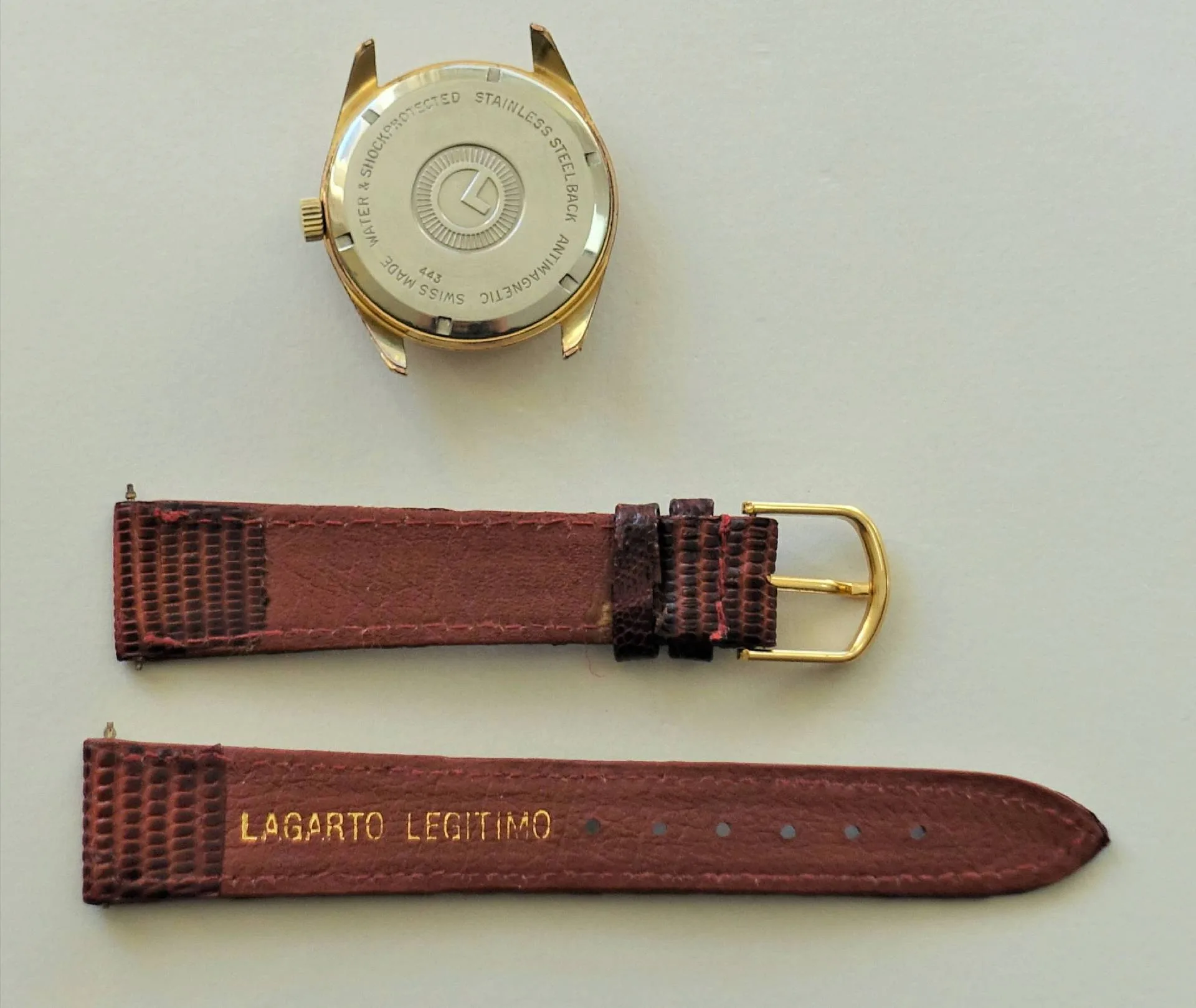 Goldfarbenes Uhrgehäuse mit braunem Lederarmband in zwei Teilen.