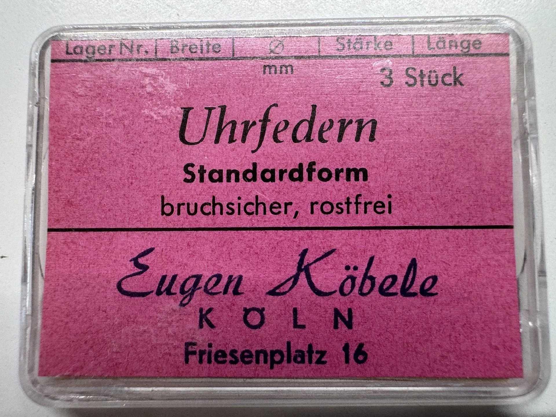 Set mit drei bruchsicheren, rostfreien Uhrfedern in einer transparenten Kunststoffbox mit pinkem Etikett.