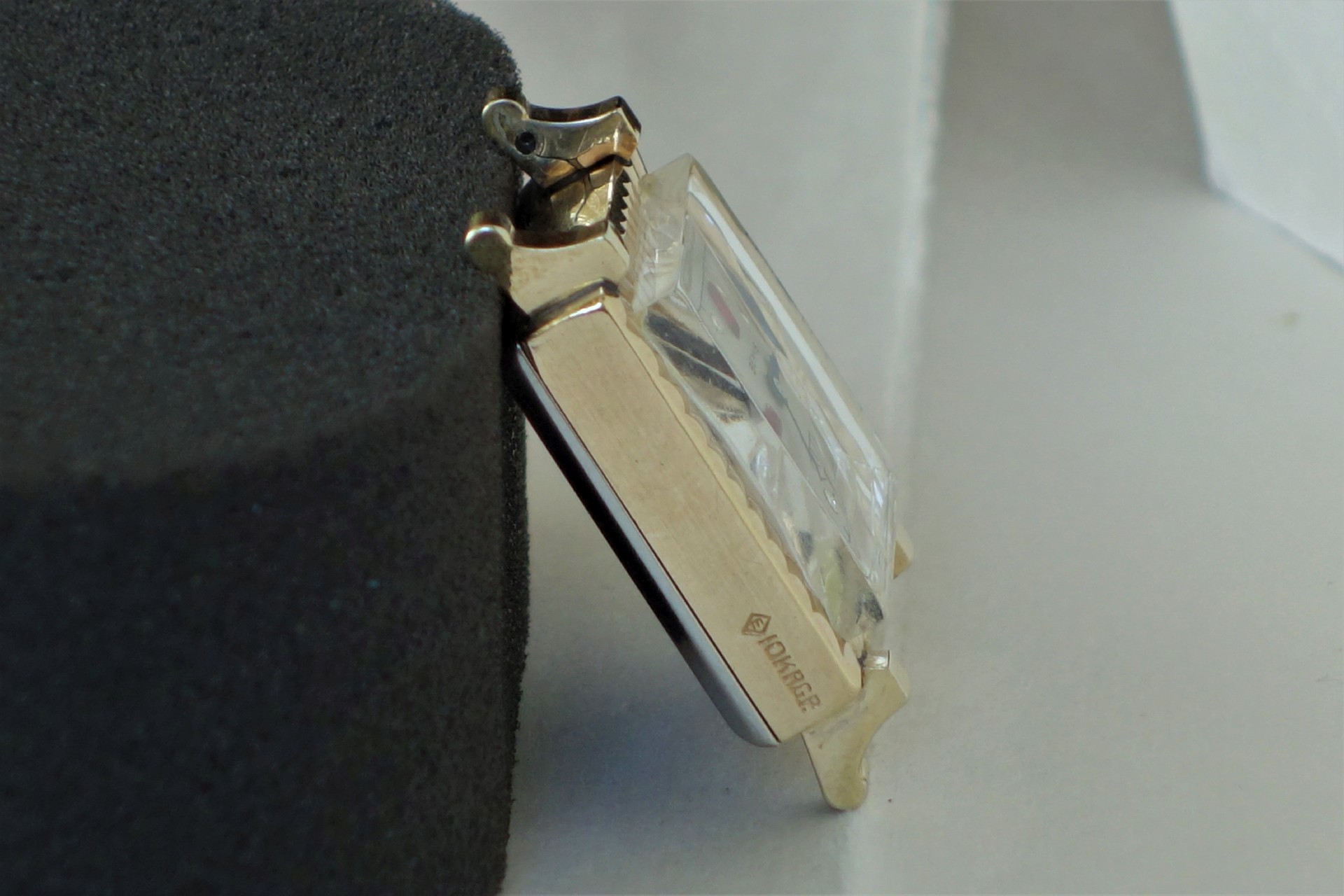 Rechteckiges Metallgehäuse für Armbanduhren mit aufgesetztem Uhrglas.