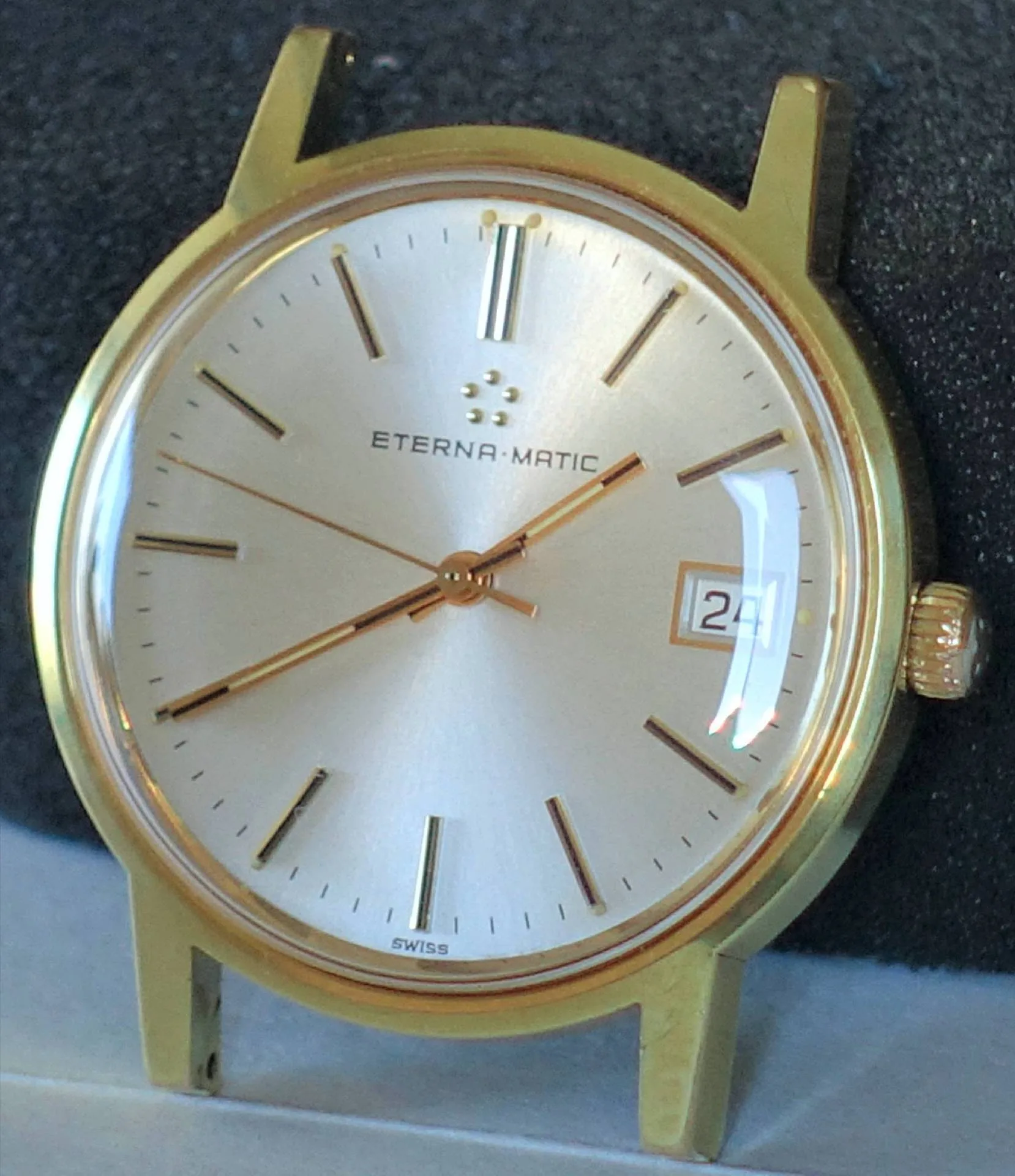 Goldfarbene Armbanduhr mit hellem Zifferblatt und Datumsanzeige.