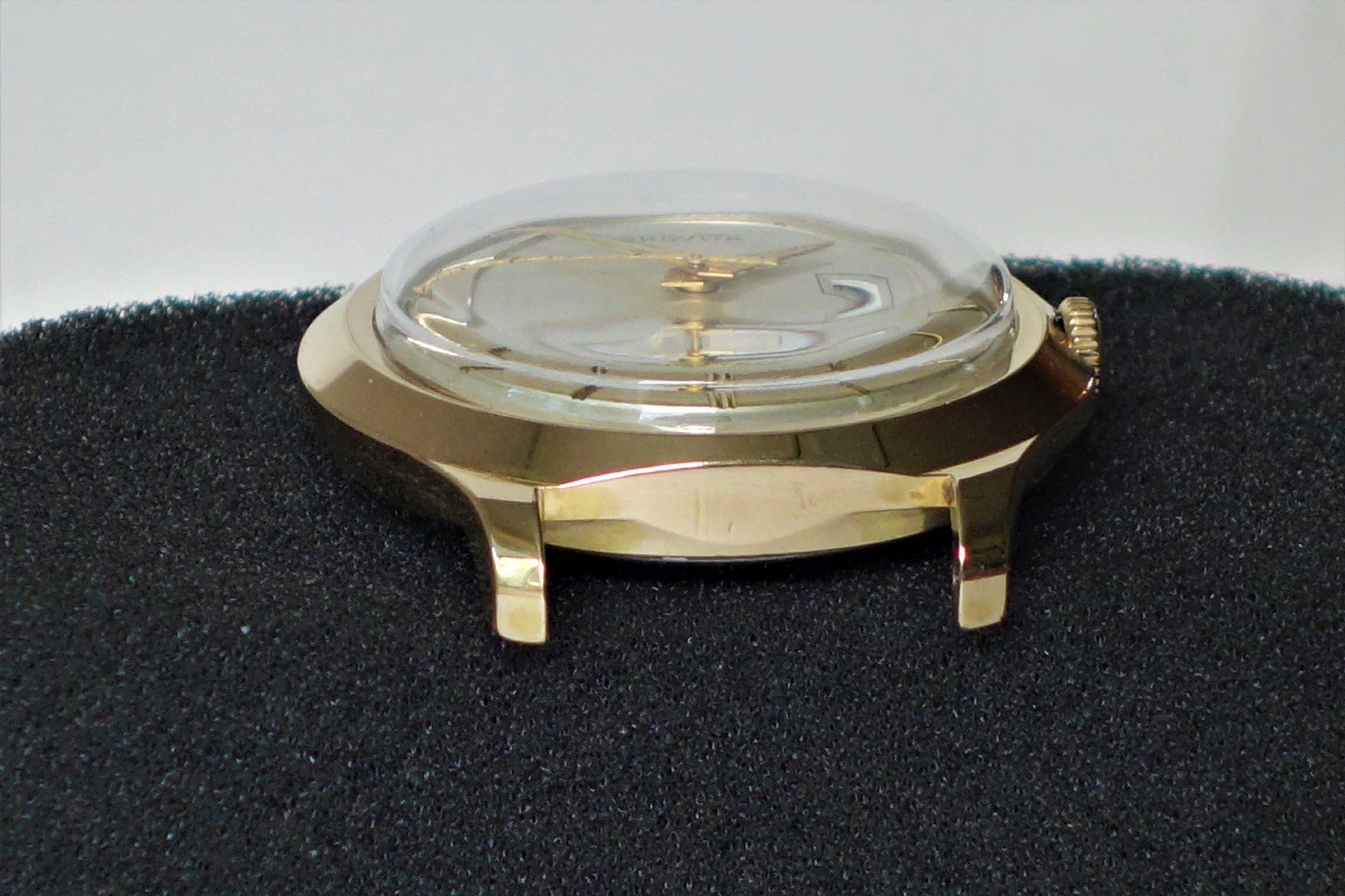 Goldfarbene Armbanduhr mit transparenter, gewölbter Abdeckung und sichtbarer Krone.